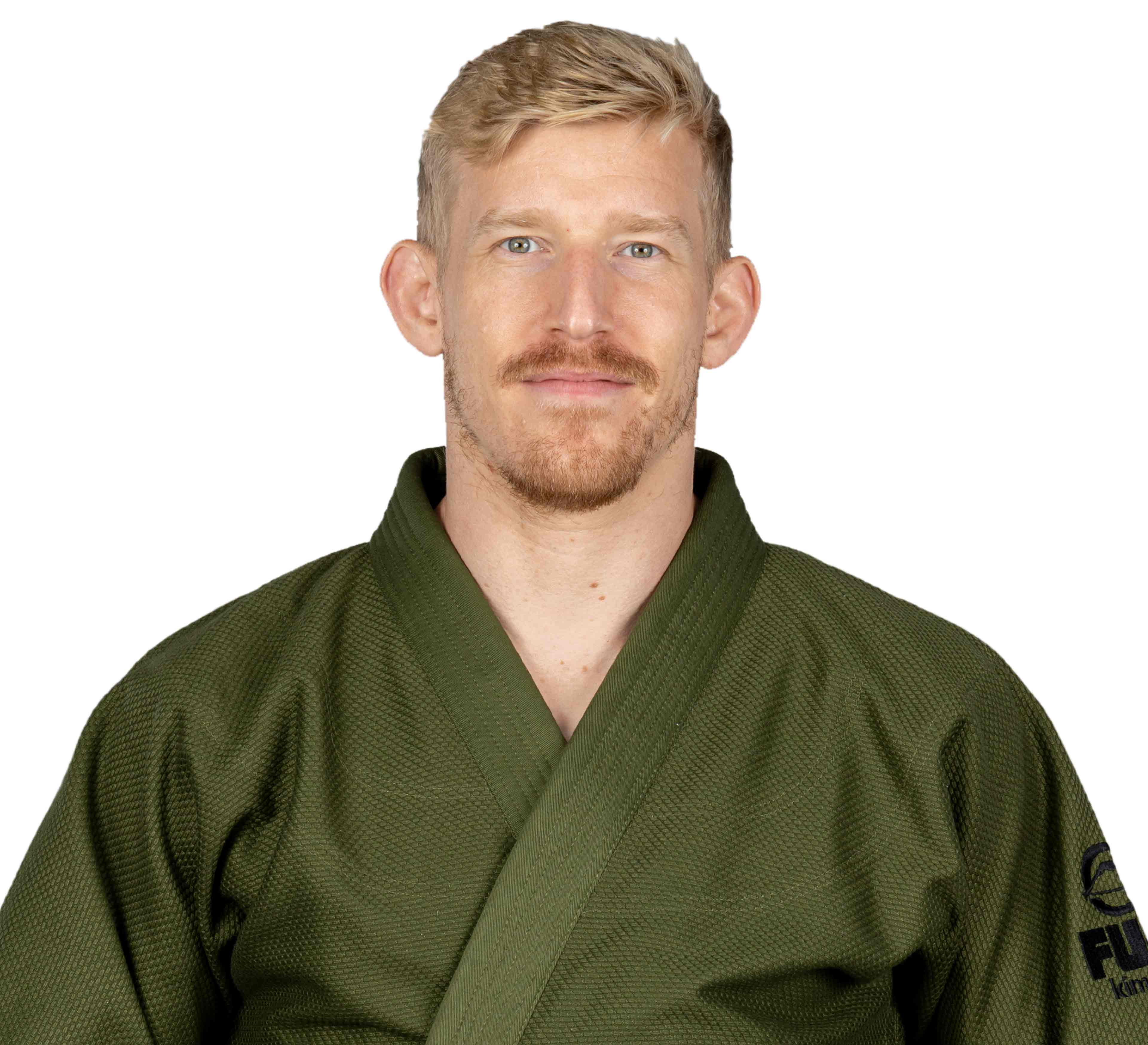 A man with short blond hair and a trimmed beard wears the All Around BJJ Gi Military Green, looking straight at the camera and smiling slightly against a plain white background.