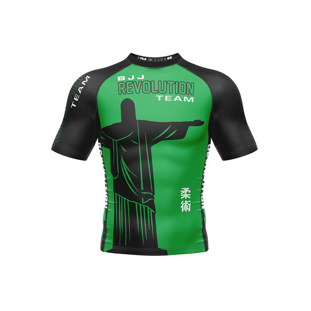 The BJJ Revolution KIDS Ranked Rashguard Short Sleeve in green features a large Christ the Redeemer graphic on the front, plus “BJJ Revolution Team” and Japanese kanji printed on the chest.