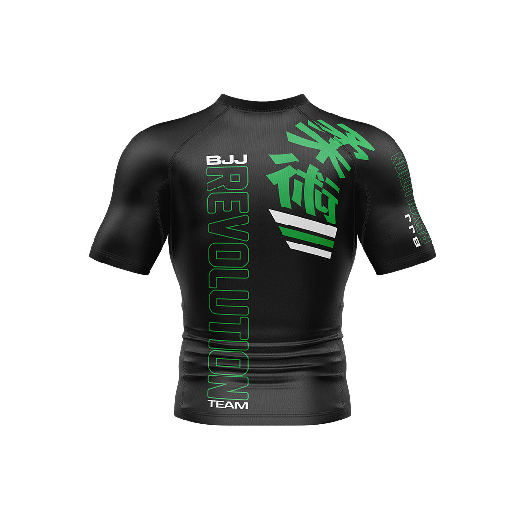 The BJJ Revolution KIDS Ranked Rashguard Short Sleeve is a black athletic rash guard with green and white "BJJ REVOLUTION TEAM" text and Japanese kanji on the front and shoulder, shown on a plain white background.