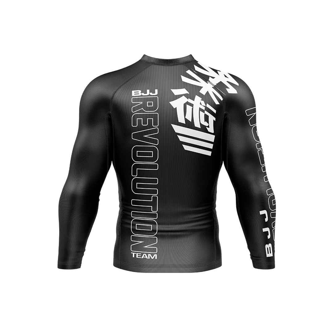 The BJJ Revolution Adult Ranked Long Sleeve Rashguard is black with "REVOLUTION" and "TEAM" in large white letters on the back, white Japanese kanji on the upper back, and branded details on the arms.