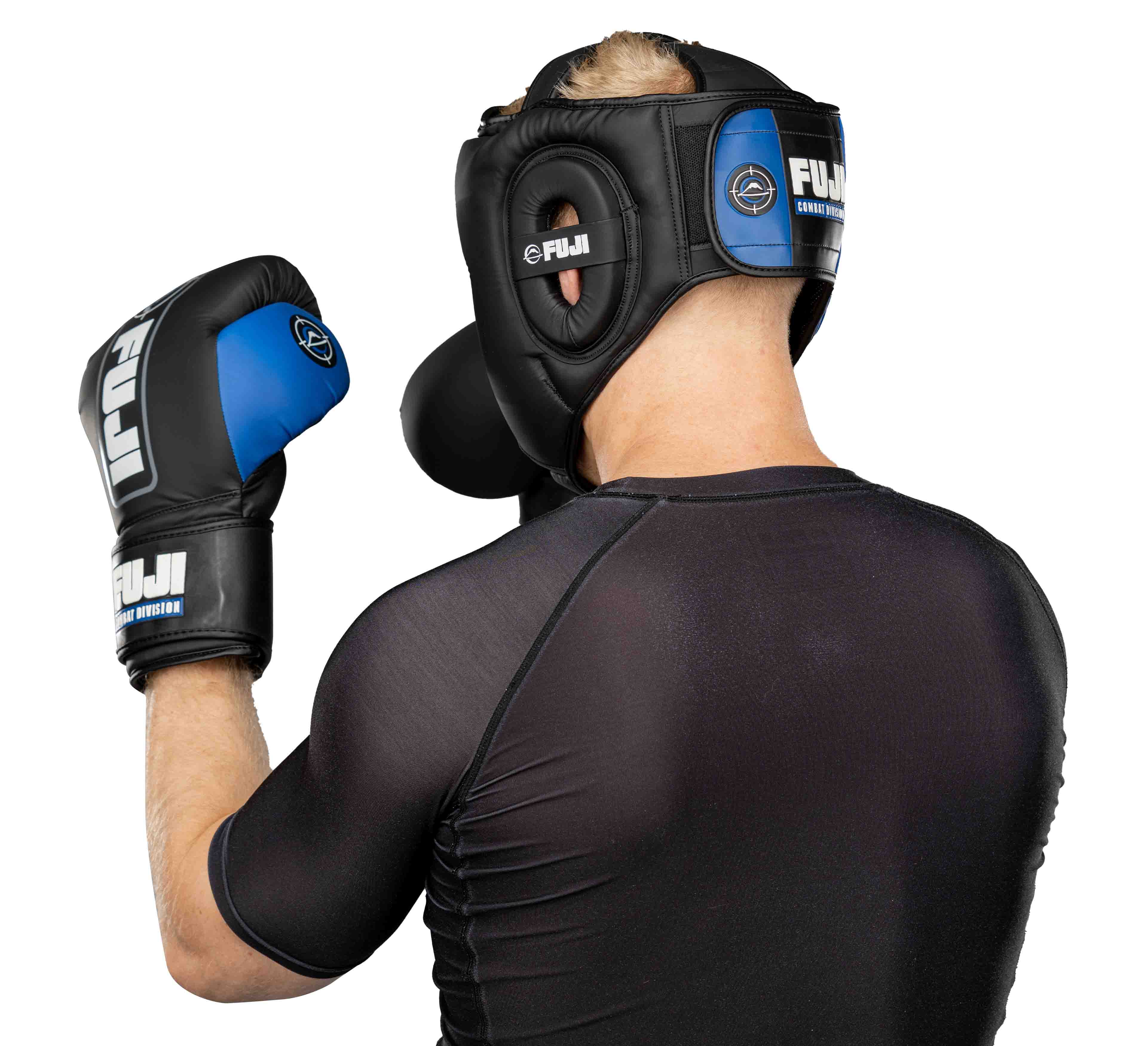 A person is shown from behind in a boxing stance wearing the Precision Striking Headgear, black-and-blue boxing gloves, and a black athletic shirt.