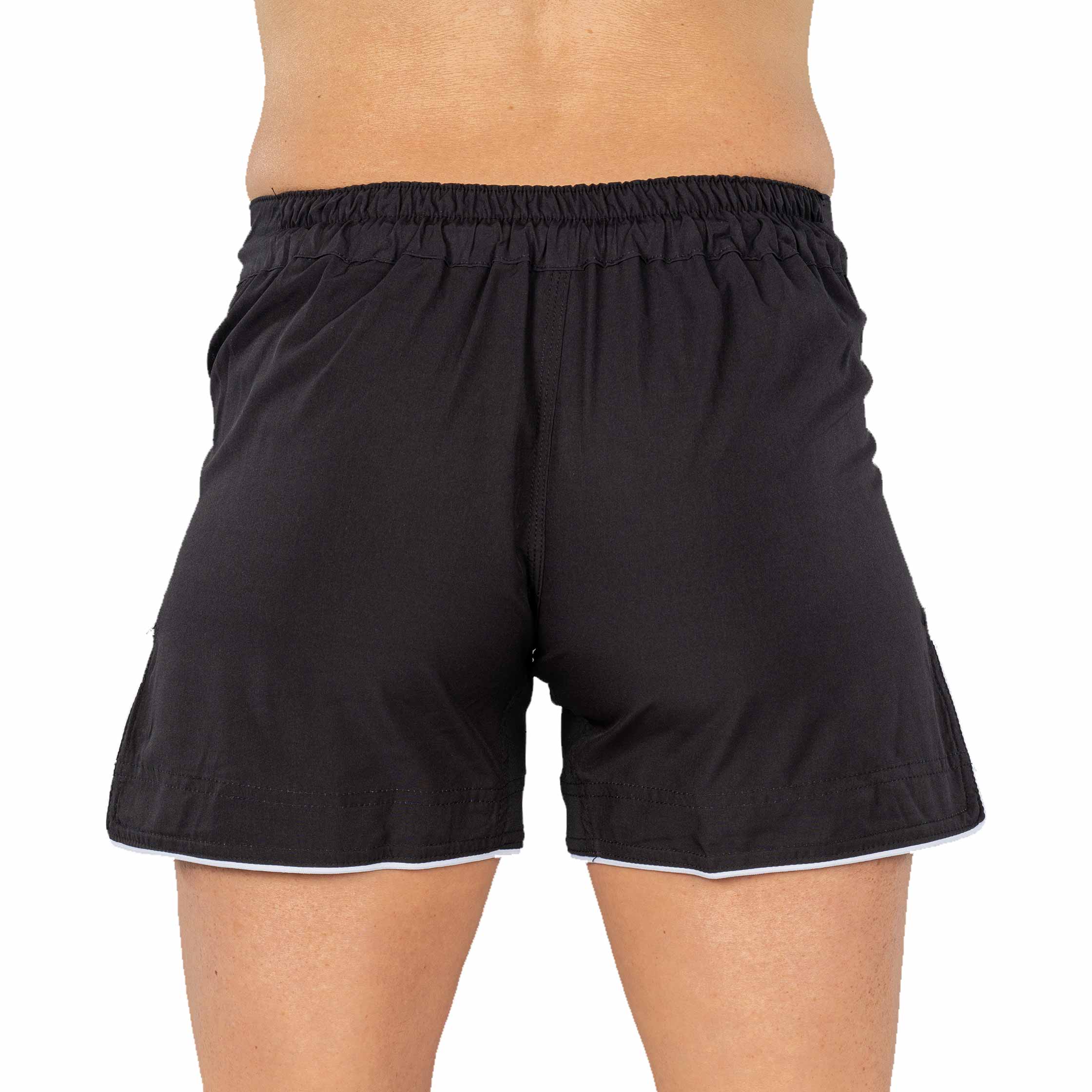 A person models the Baseline Womens Black Grappling Shorts, featuring an elastic waistband, shown from waist to mid-thigh against a plain white background.