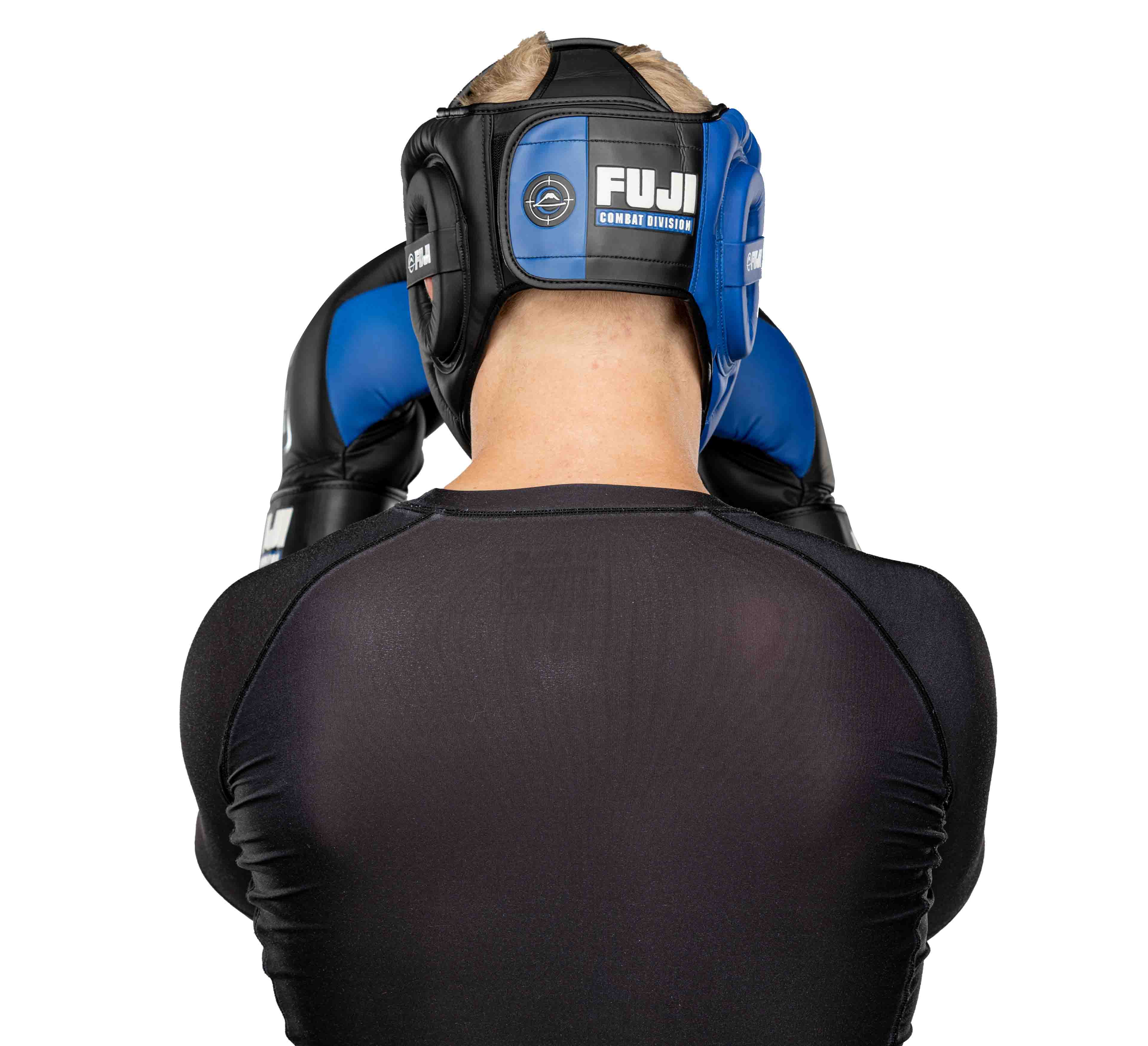 A person wearing black and blue Precision Striking Headgear with the FUJI logo on the back, facing away from the camera, along with matching gloves and a black athletic shirt.