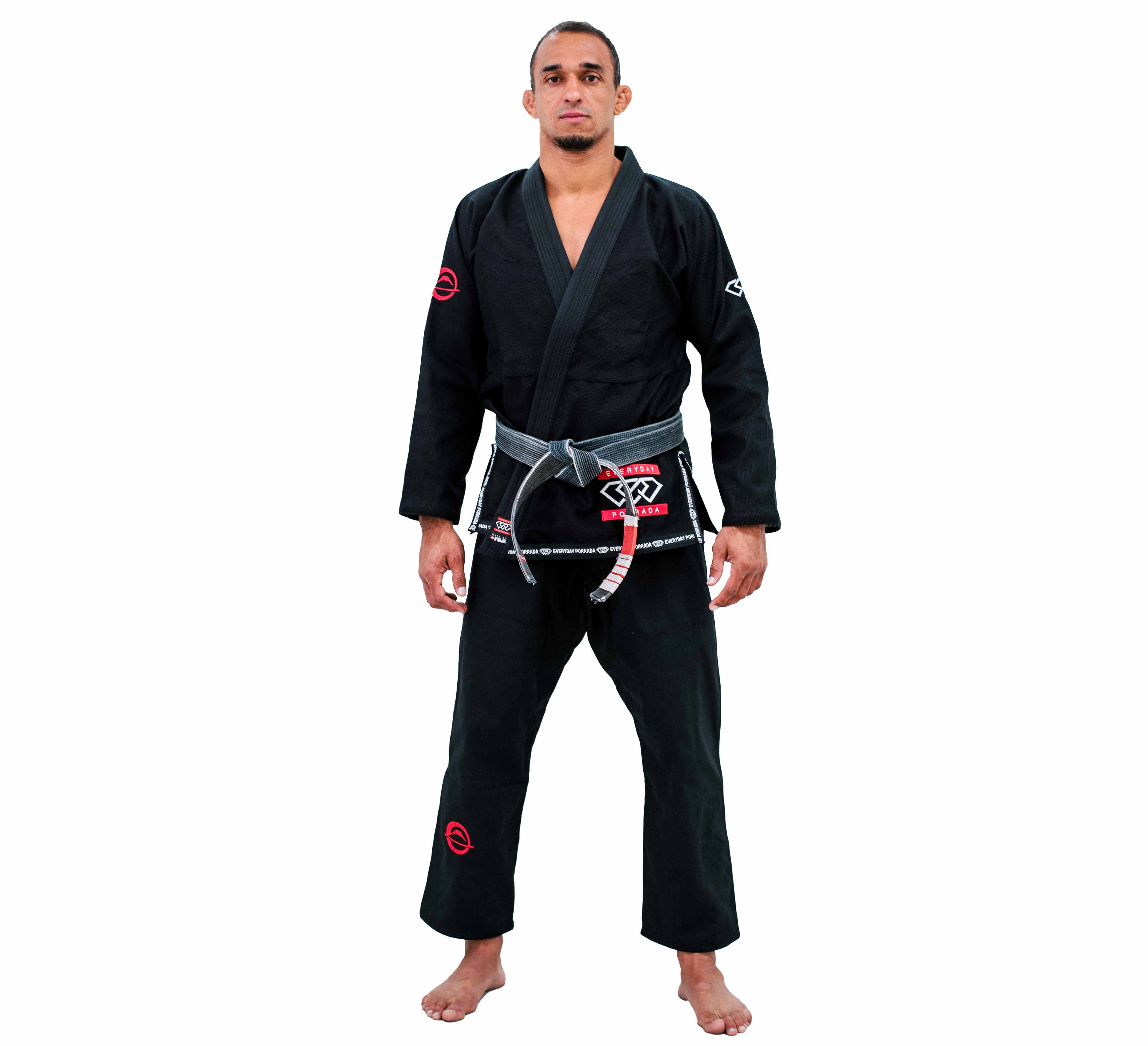 A barefoot person wearing the Everyday Porrada Flow-Tech BJJ Gi in black, featuring red and white patches and a gray belt with red and white stripes, stands facing forward against a plain white background.
