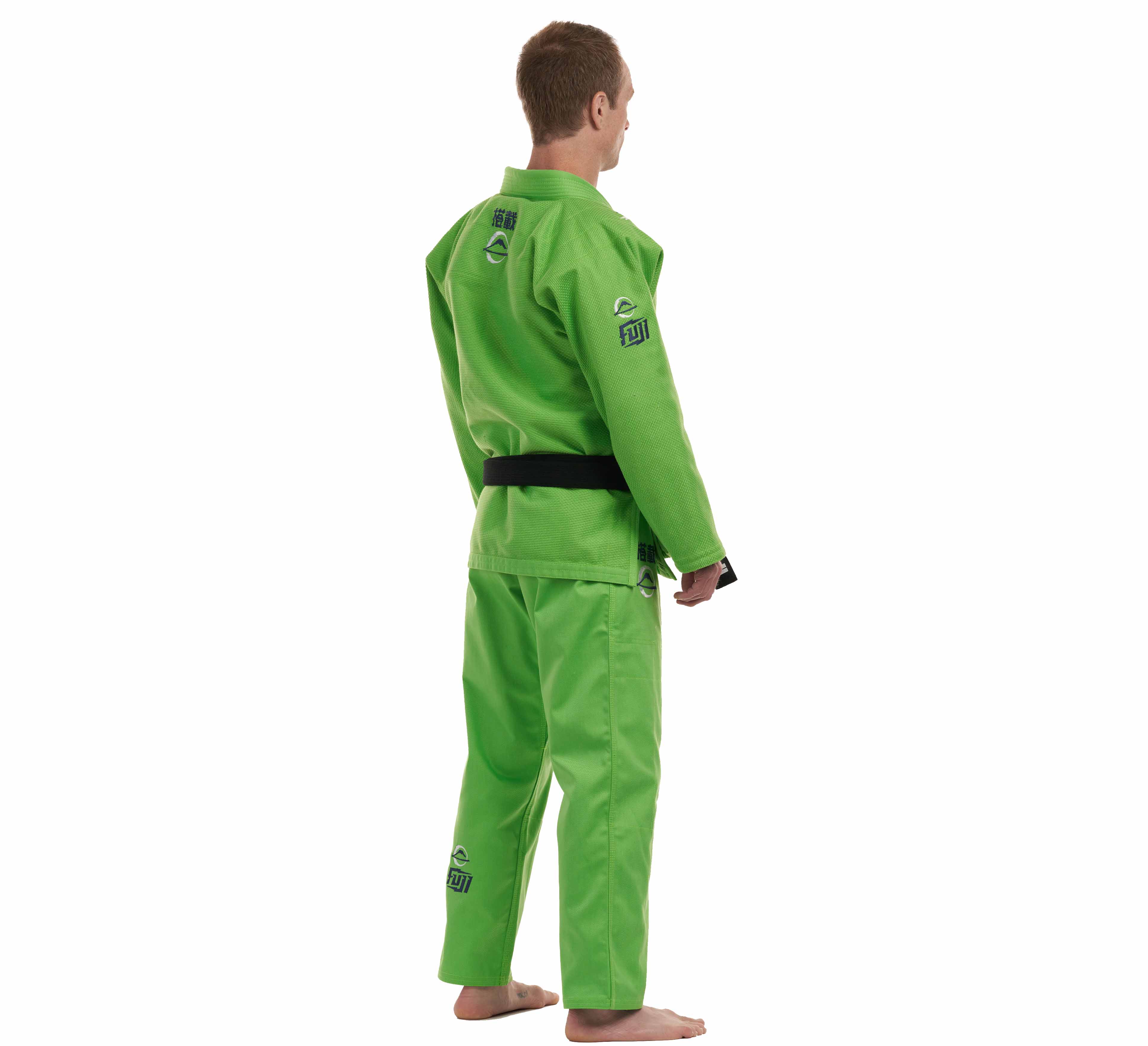 A person in the All Around BJJ Gi Electric Green Edition with a black belt stands barefoot on a white background, facing away from the camera. Patches and logos appear on the gi’s back, arm, and pants.