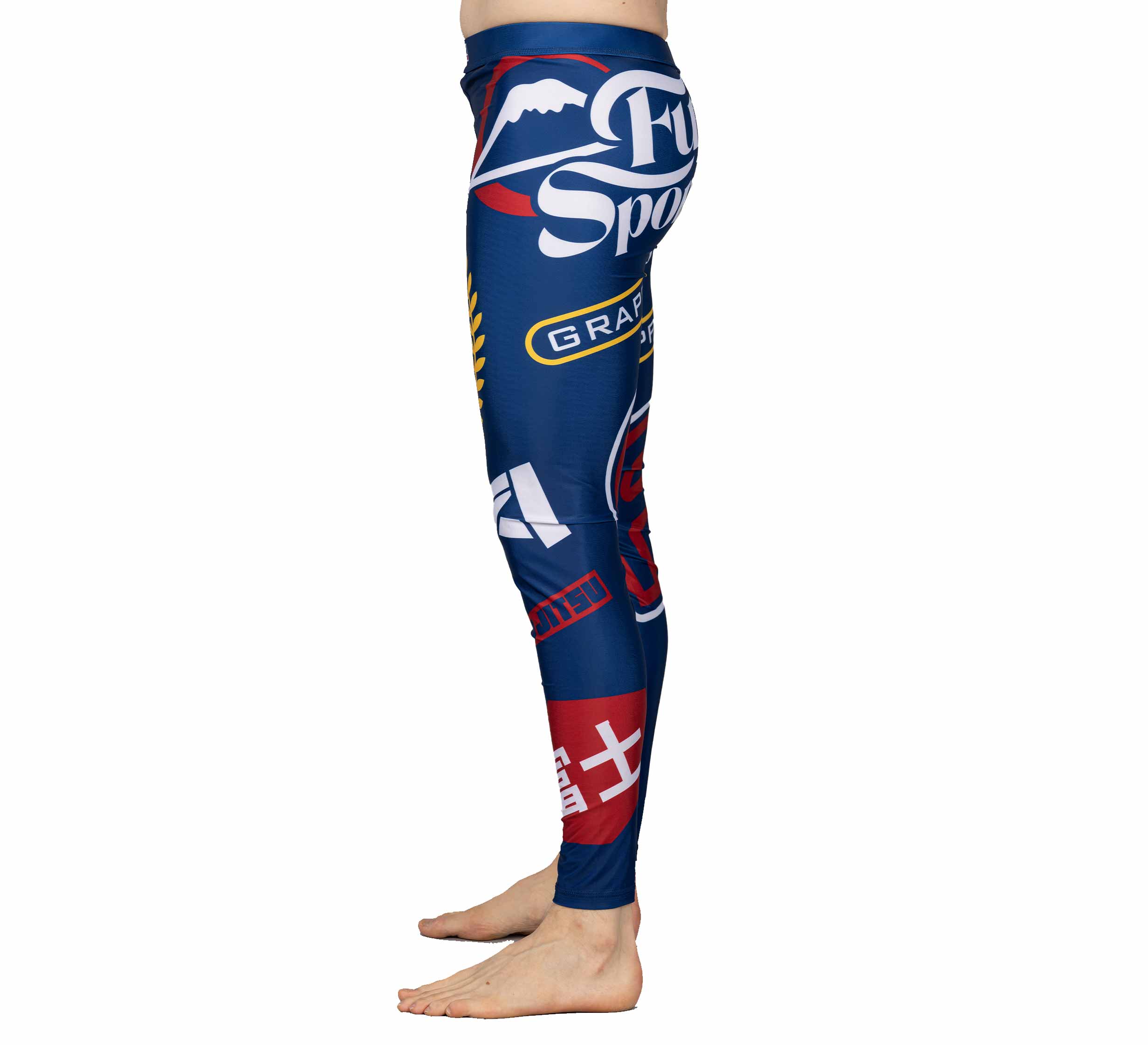 Person standing sideways, wearing XTR Extreme V1 Grappling Spats Navy featuring white, red, and yellow logos and graphic designs. Only the lower body is visible against a plain white background.