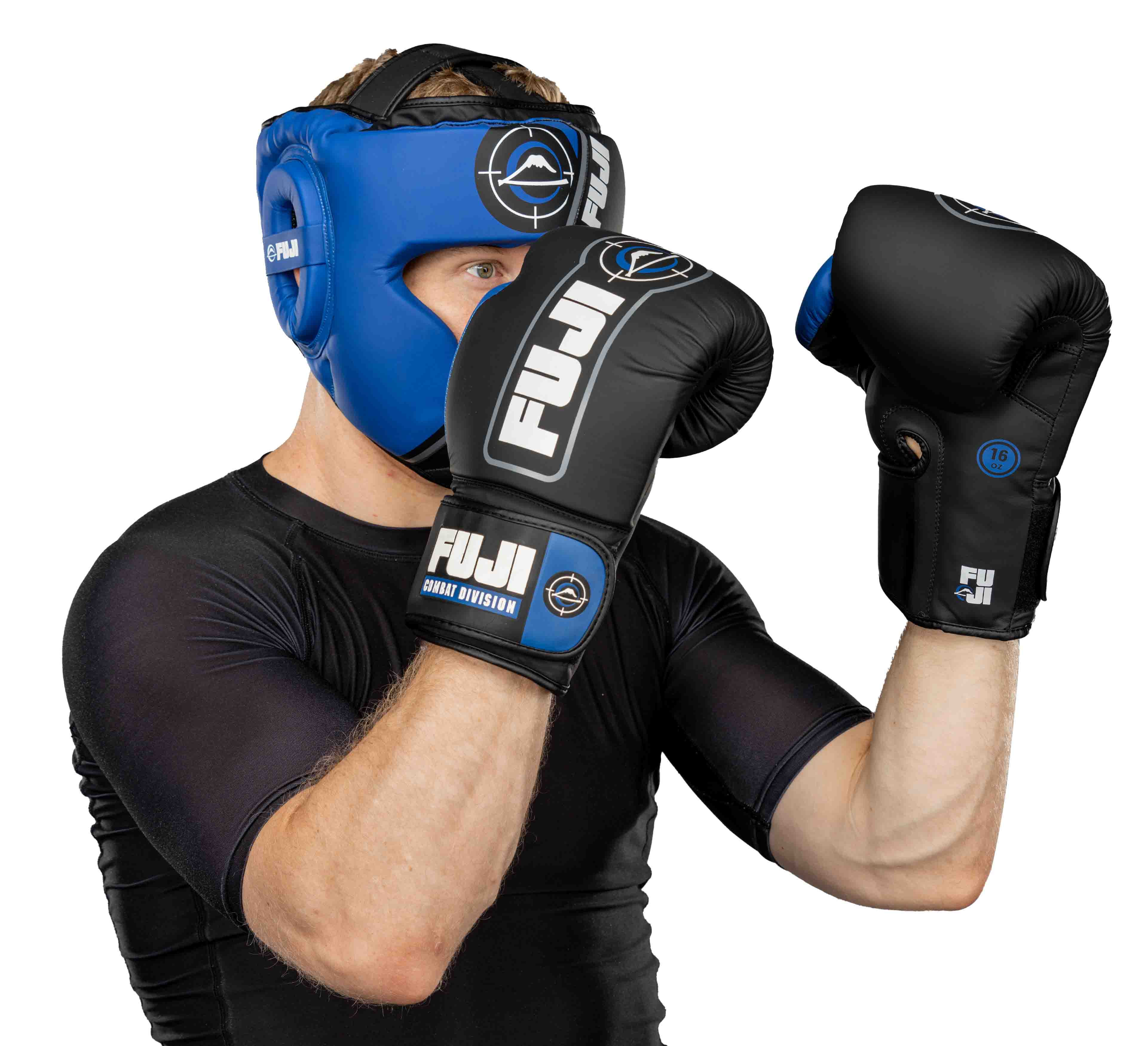 A person wearing FUJI Precision Striking Headgear and black FUJI boxing gloves is standing in a defensive boxing stance, also sporting a black short-sleeve compression shirt.