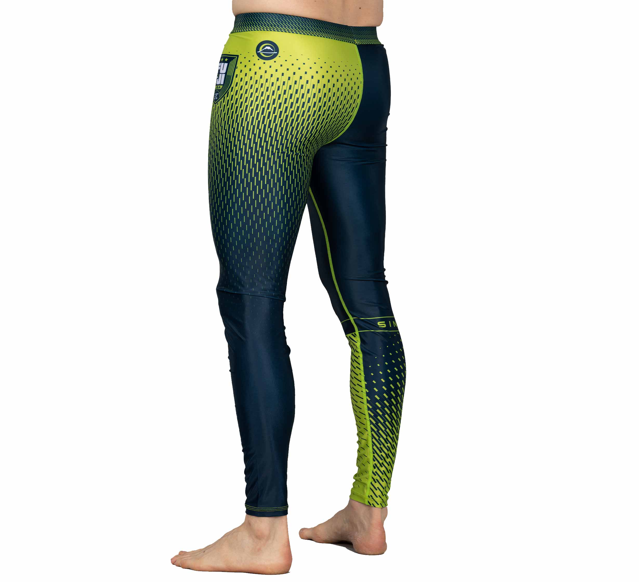 A person stands barefoot wearing Match Grappling Spats Navy—fitted, long leggings with a gradient from dark blue to neon yellow and a geometric dot design. The image features side and back views of these athletic spats.
