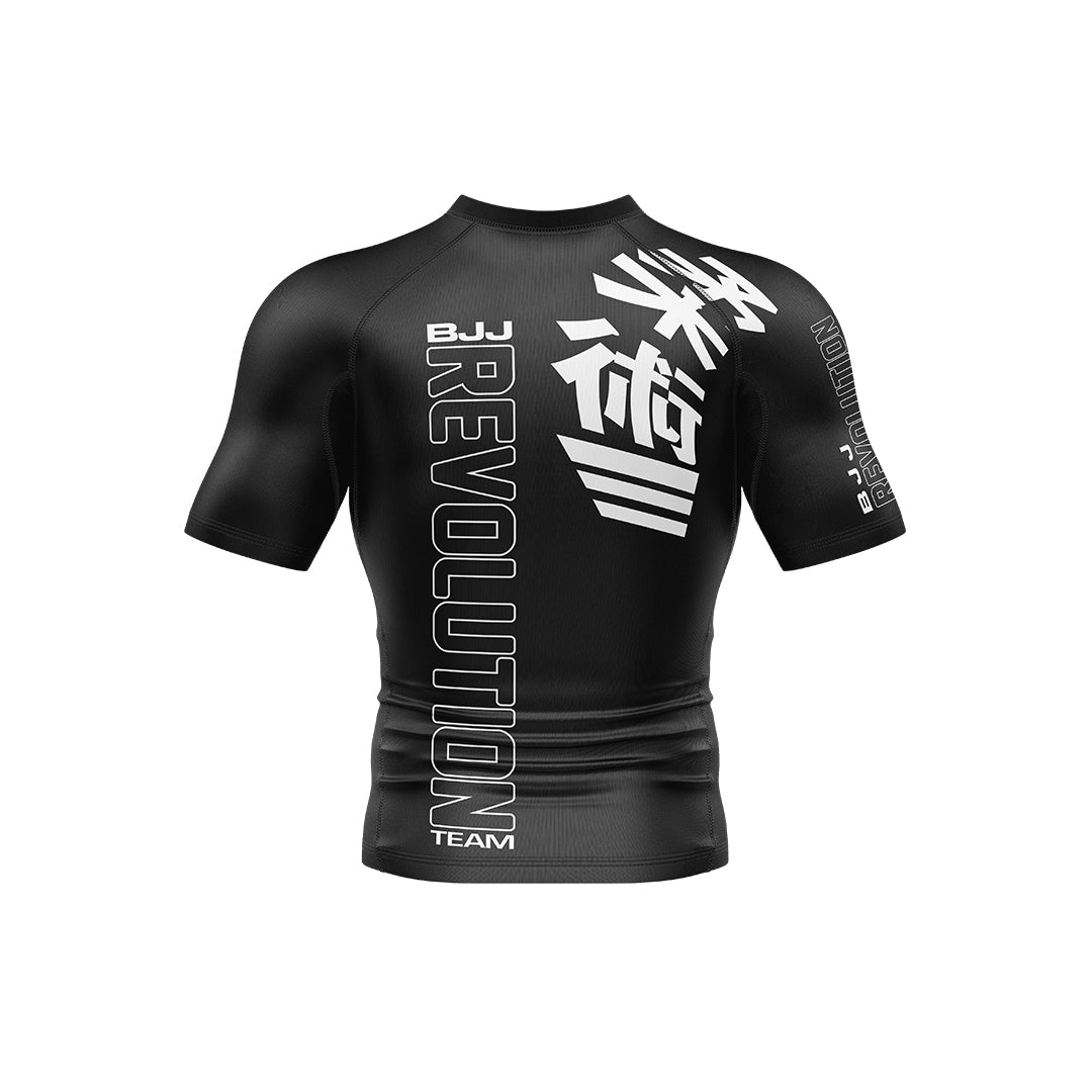 The BJJ Revolution Adult Ranked Short Sleeve Rashguard is a fitted black top featuring "REVOLUTION TEAM" and "BJJ" in bold white letters with vertical Japanese kanji on the front, shown on a plain white background.