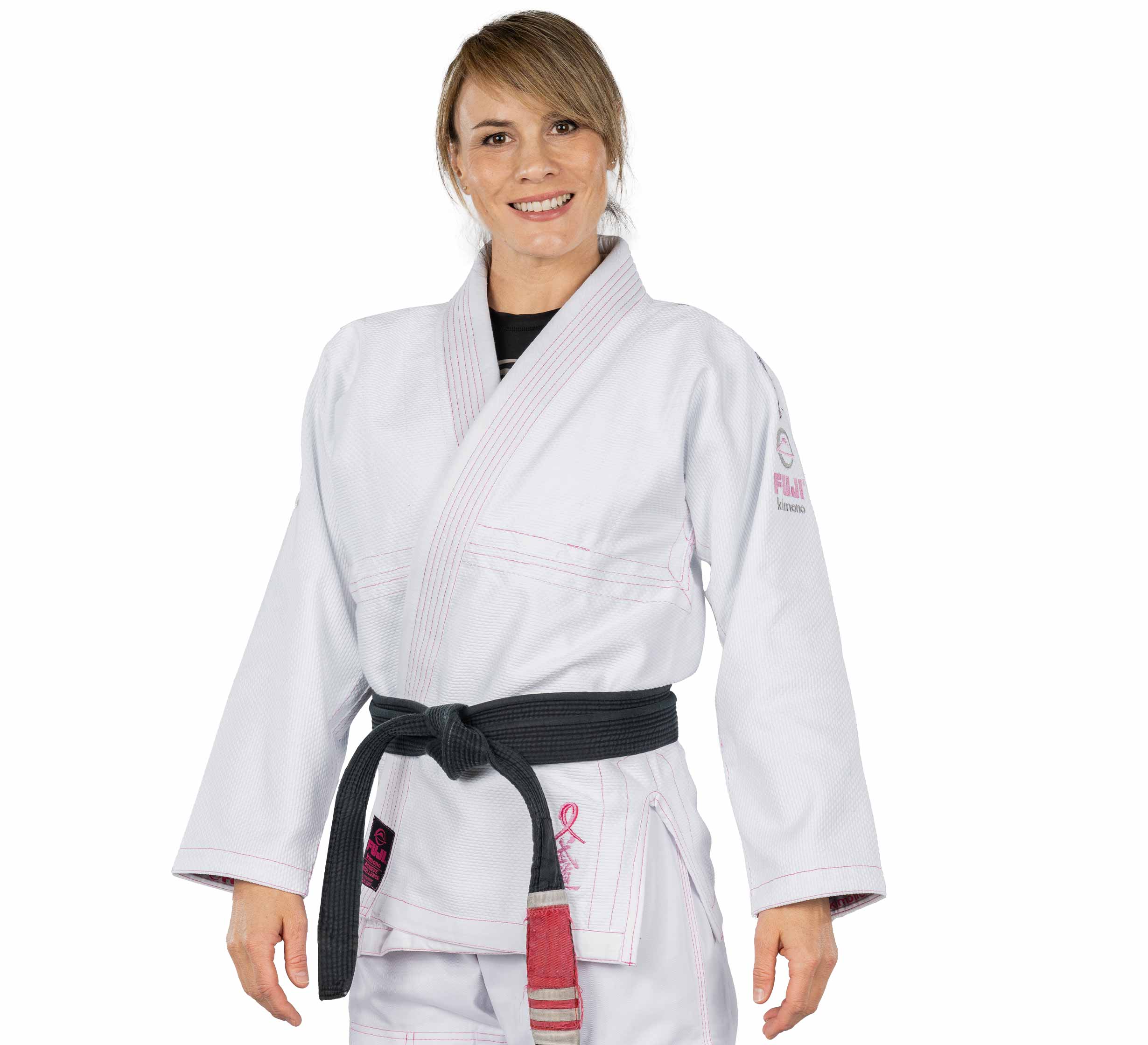 A woman smiles in the Blossom Womens Jiu Jitsu Gi White with a black belt, standing against a plain white background.
