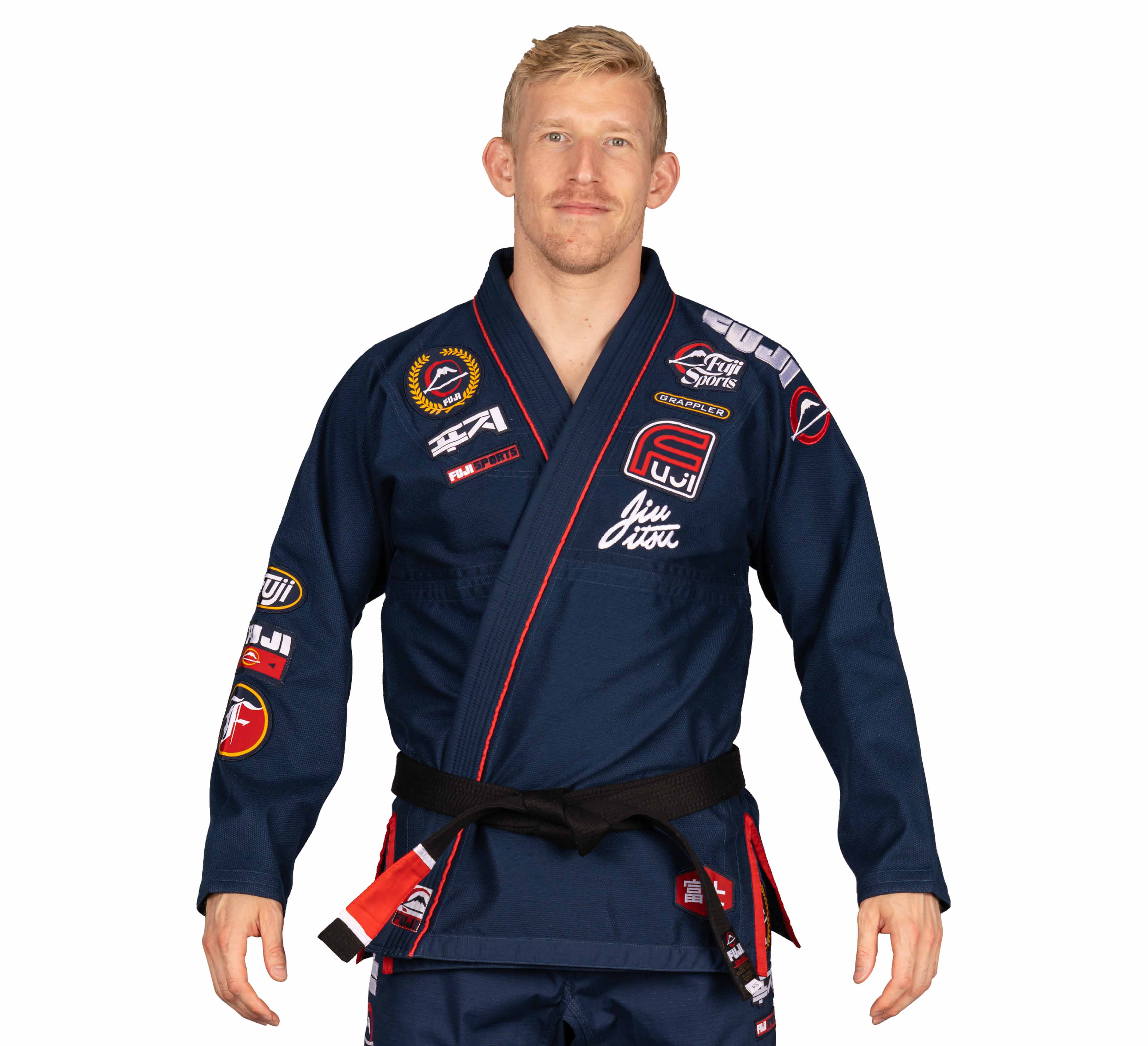 A man stands facing forward against a plain white background, wearing the Suparaito BJJ Gi XTR Edition Navy adorned with colorful patches and a black belt.