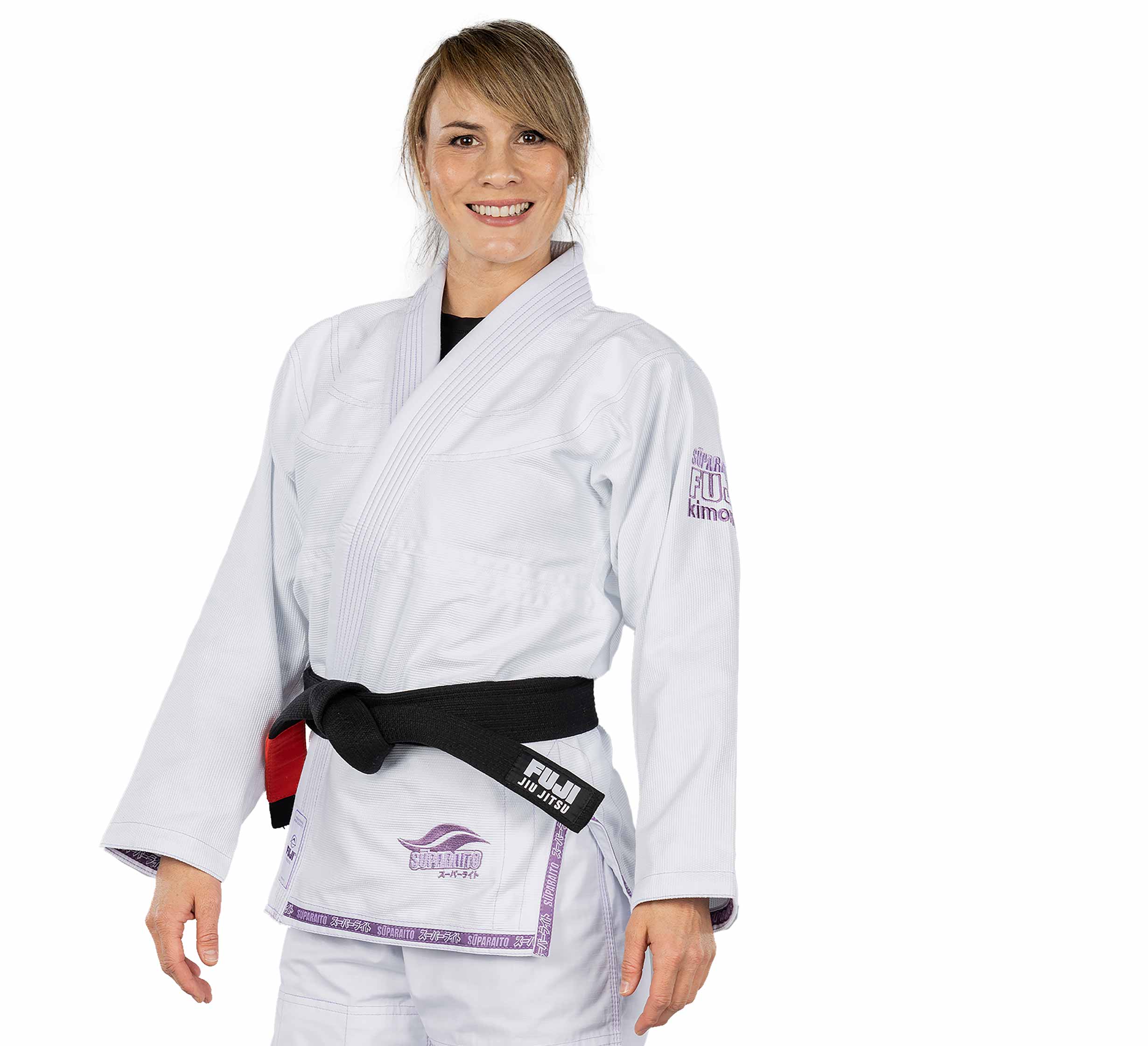 A woman wears the Suparaito Womens BJJ Gi Purple, featuring white fabric with purple accents and a black belt, as she smiles against a plain white background.