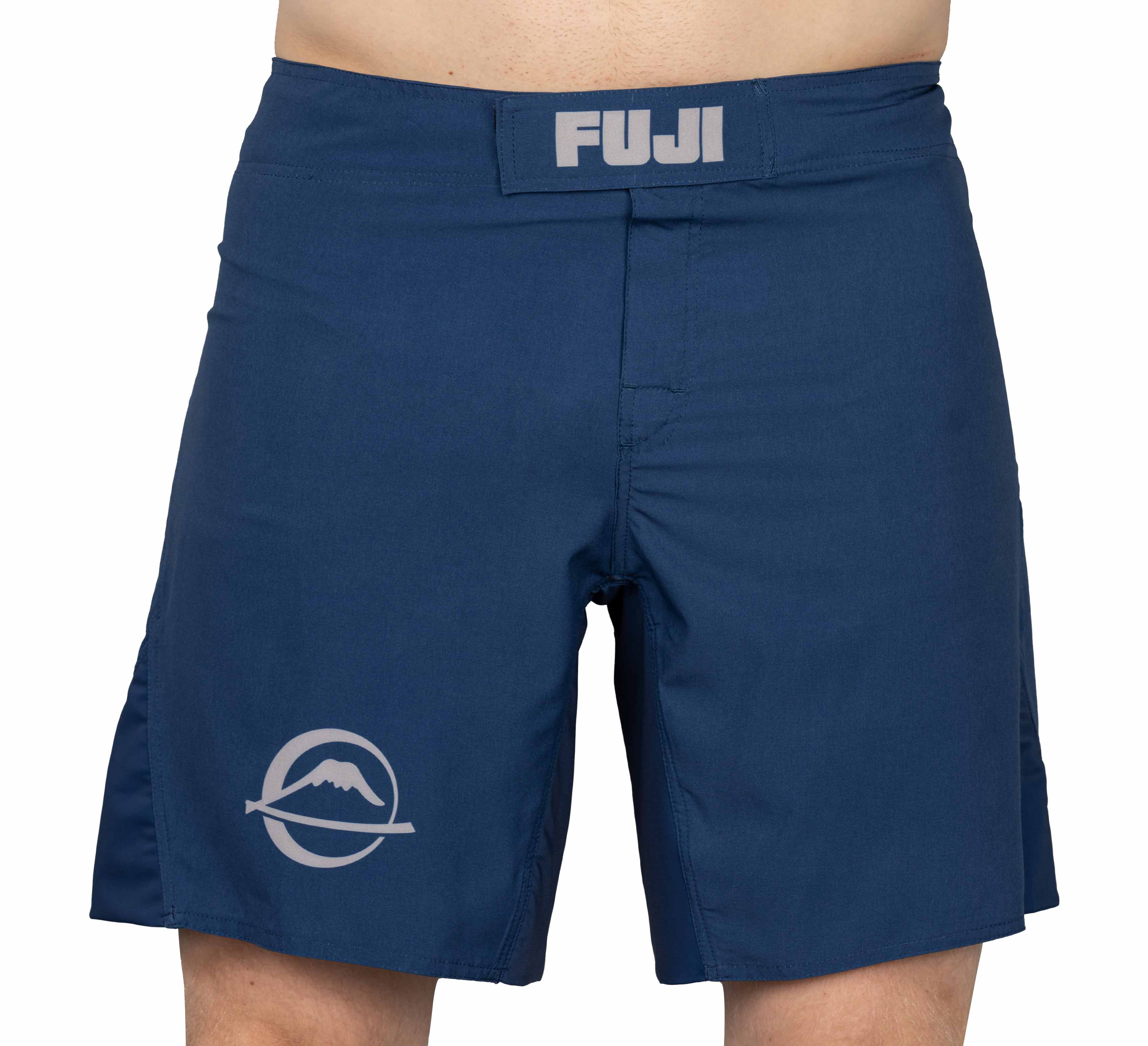 The Baseline Fight Shorts in navy feature the "FUJI" logo on the waistband and a circular mountain logo on the left leg. Only the waist to mid-thigh area is shown being worn.