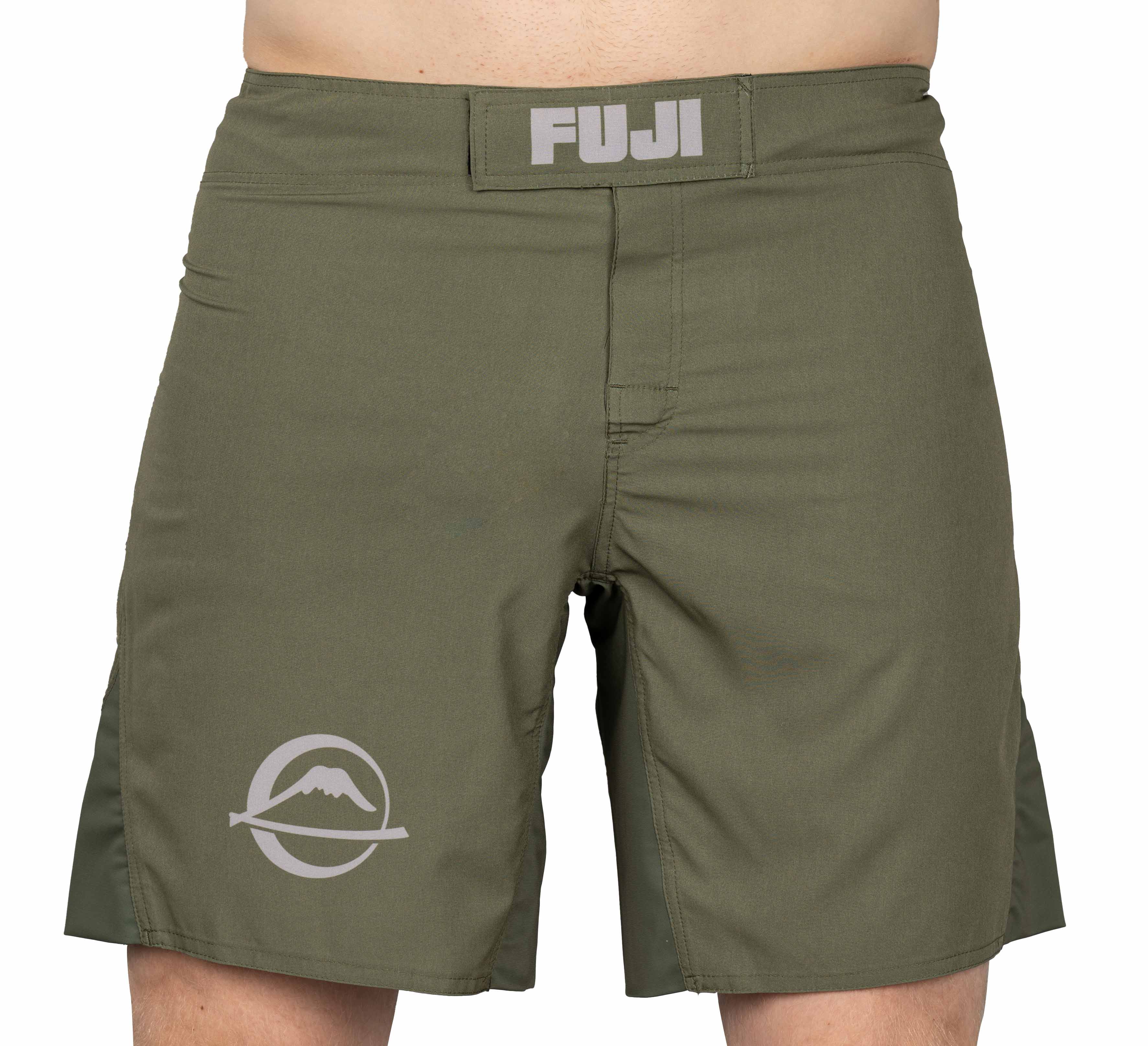 A person wearing Baseline Fight Shorts in military green with "FUJI" on the waistband and a mountain logo on the left leg. Only the lower torso and upper legs are visible.