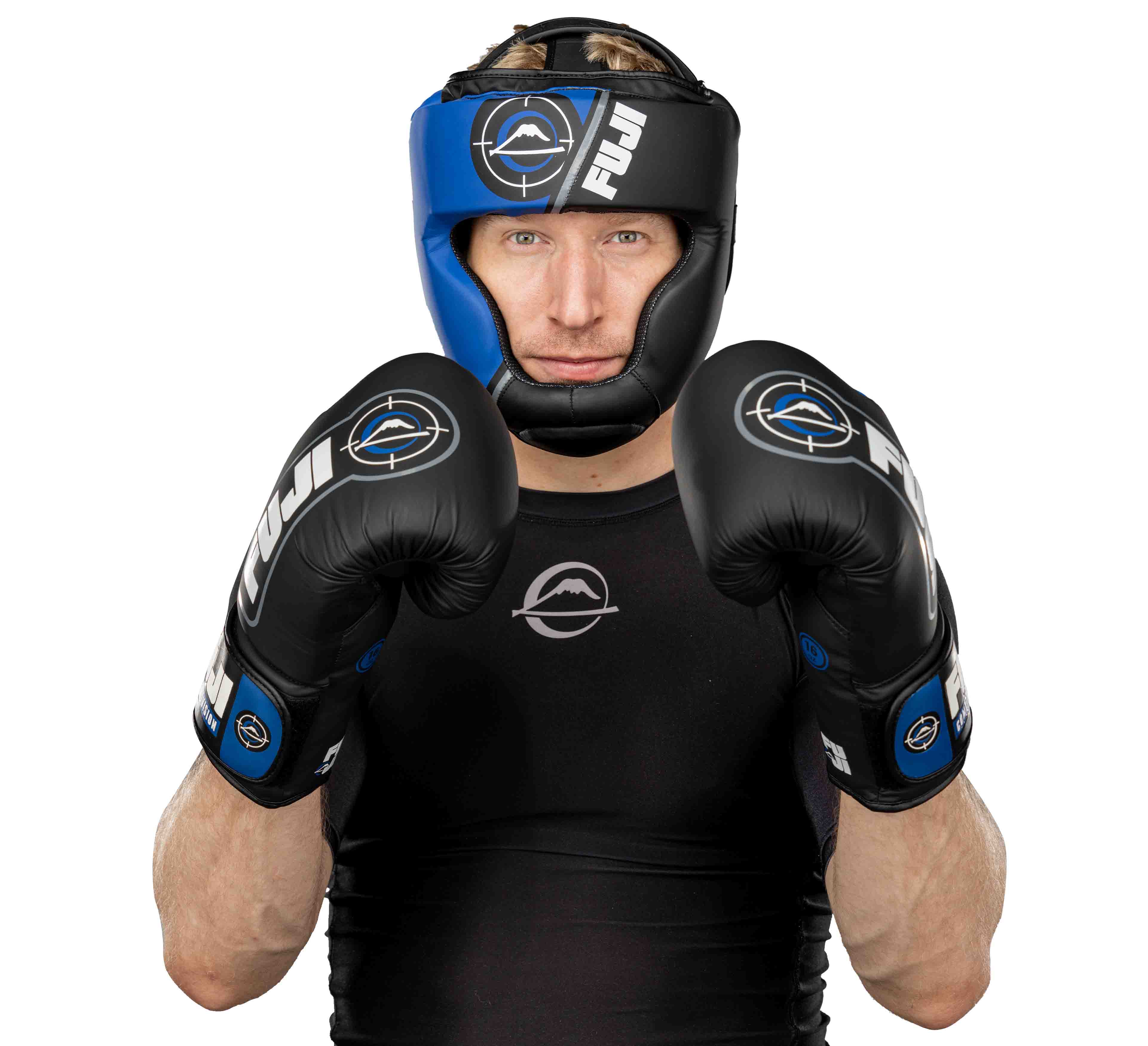 A male boxer in a black athletic shirt and black boxing gloves faces forward in a defensive stance, wearing Precision Striking Headgear, against a white background.