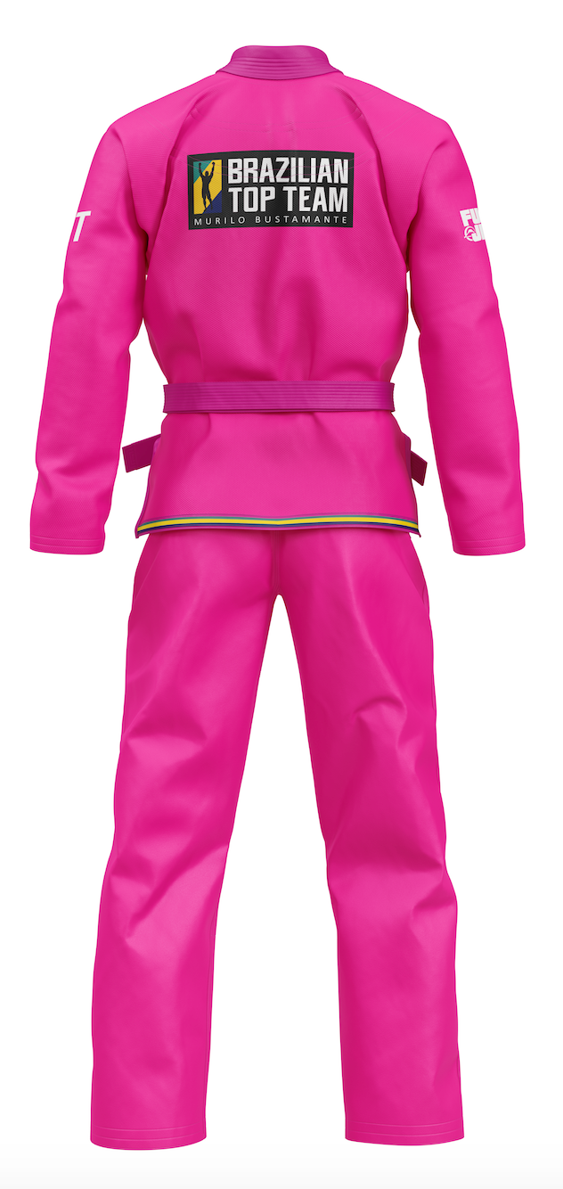 The BTT Standard Women's Gi - Color is displayed from the back in bright pink, featuring a “Brazilian Top Team” patch on the upper back, a black belt at the waist, and set against a plain white background.