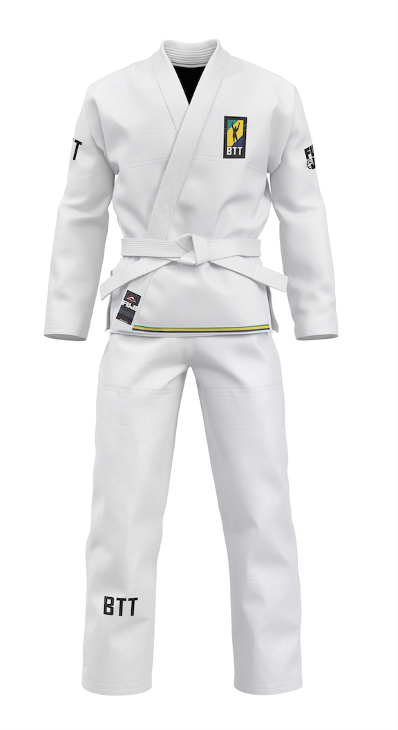 The BTT Standard Women's Gi - White includes a white belt, features black BTT text and a yellow, blue, and black chest patch with a silhouette. The gi is shown on a white background.