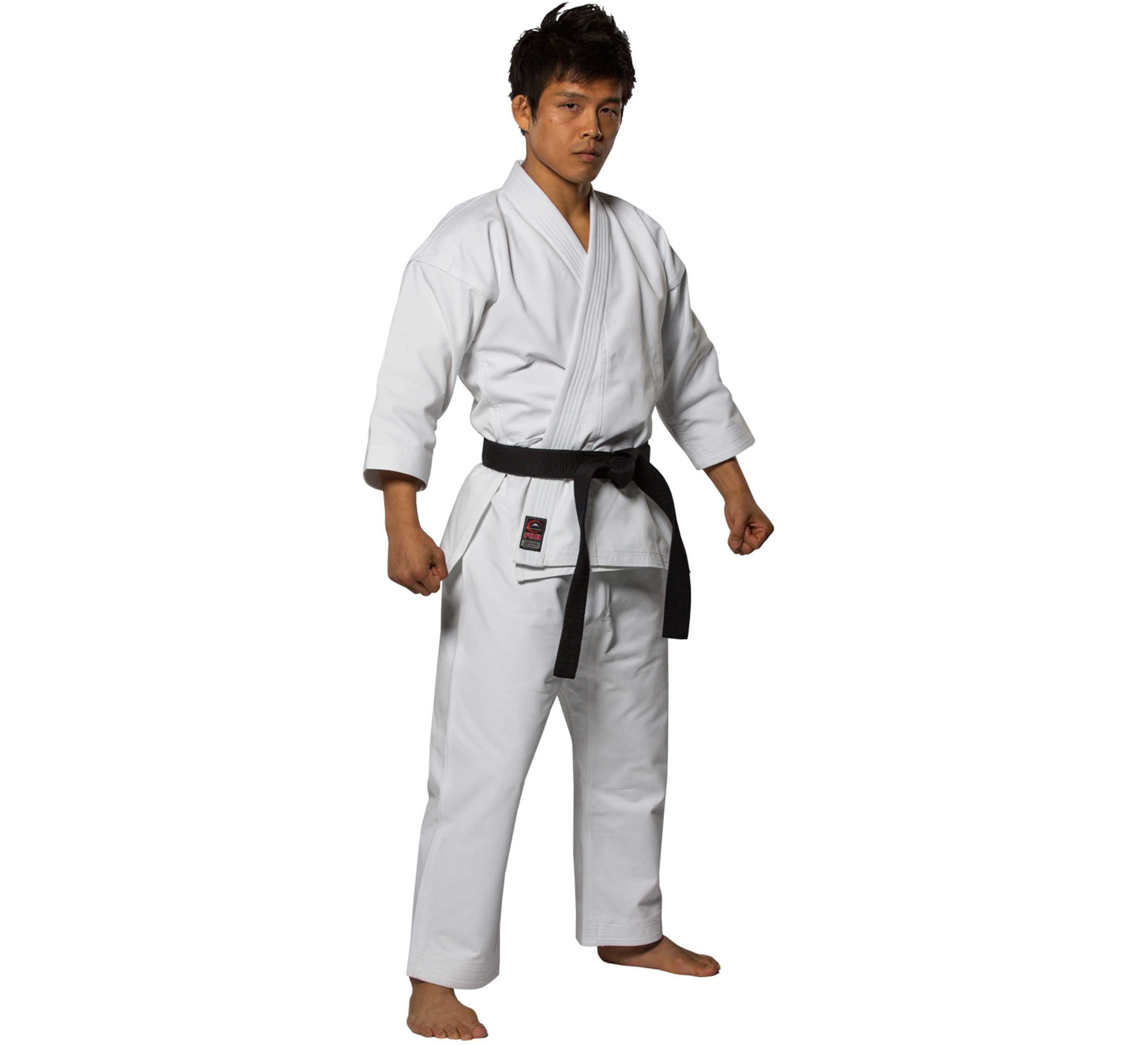 Wearing the Advanced Brushed Karate Gi and a black belt, a person stands barefoot with clenched fists, exuding confidence as they look forward.