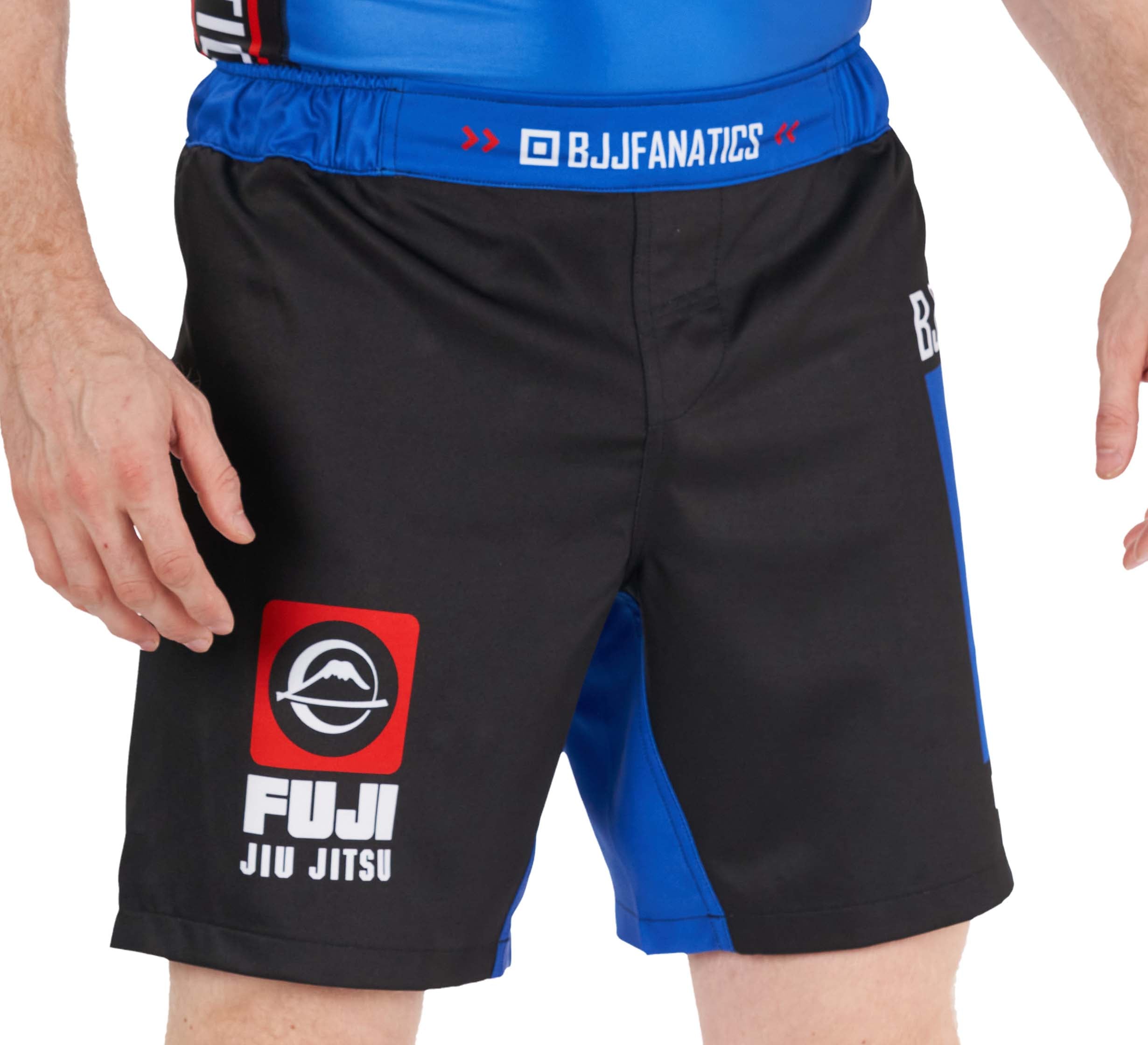 A person is shown from the waist to mid-thigh wearing BJJ Fanatics Lightweight Shorts Blue, featuring black and blue colors and branded with BJJ Fanatics.