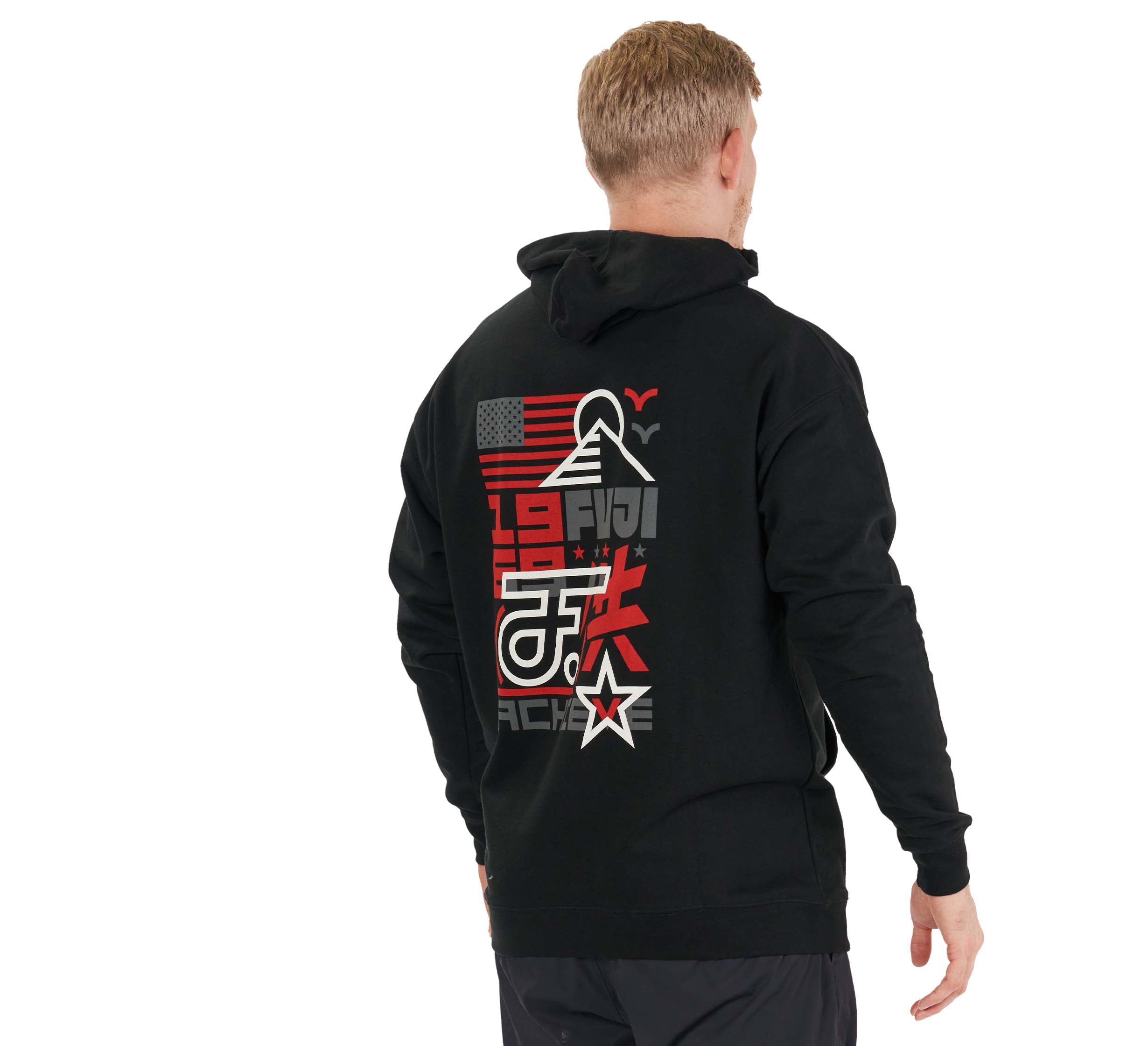 A man stands with his back to the camera in an Achieve Hoodie Black, featuring bold graphic designs—an American flag, mountain, numbers, and symbols in red, white, and gray—against a white background.