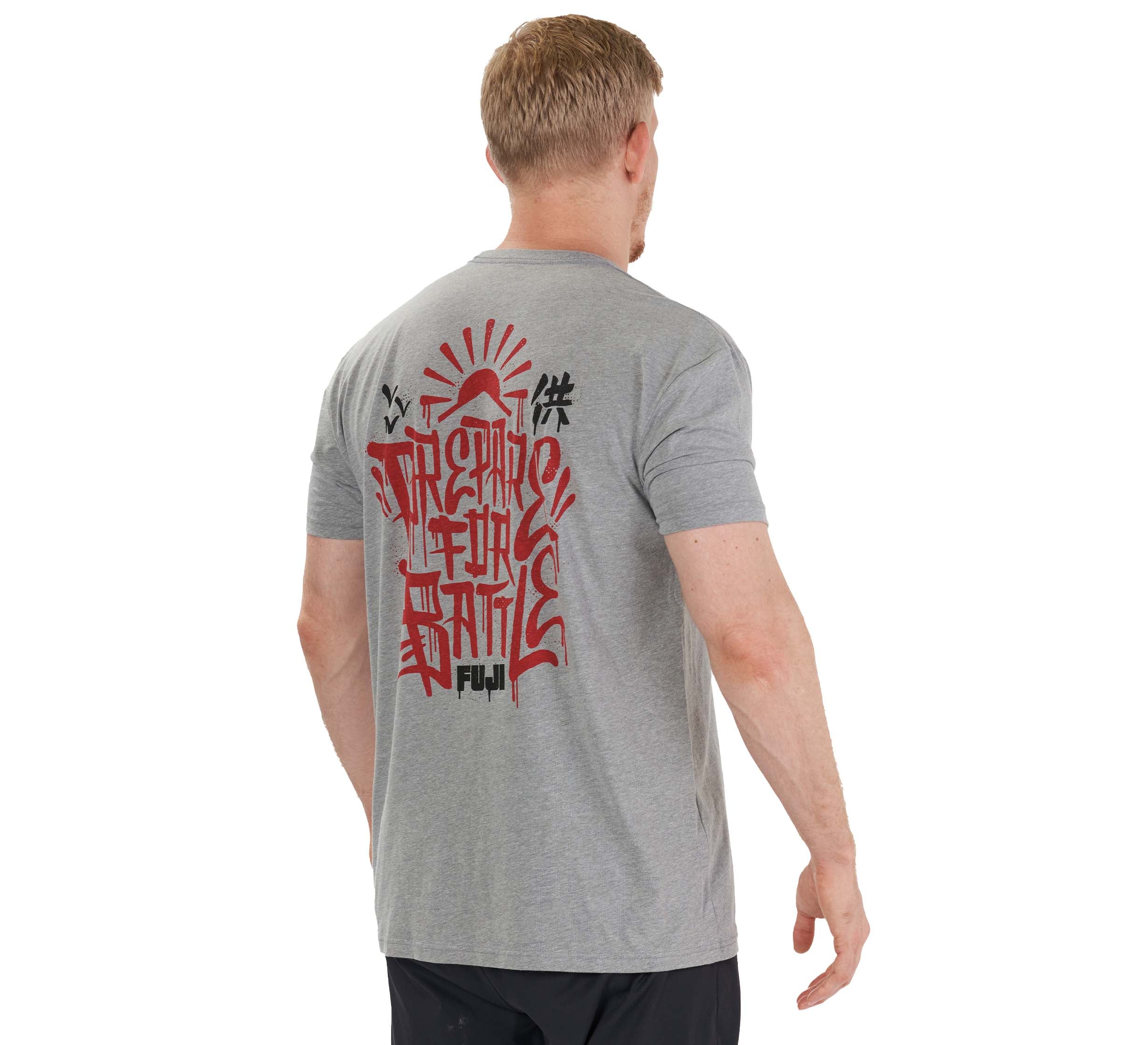 A man with short blond hair, wearing the Prepare For Battle T-Shirt Heather Grey and black shorts, faces away from the camera. Red and black stylized graphics and "Fuji" are visible on the back of his T-shirt.