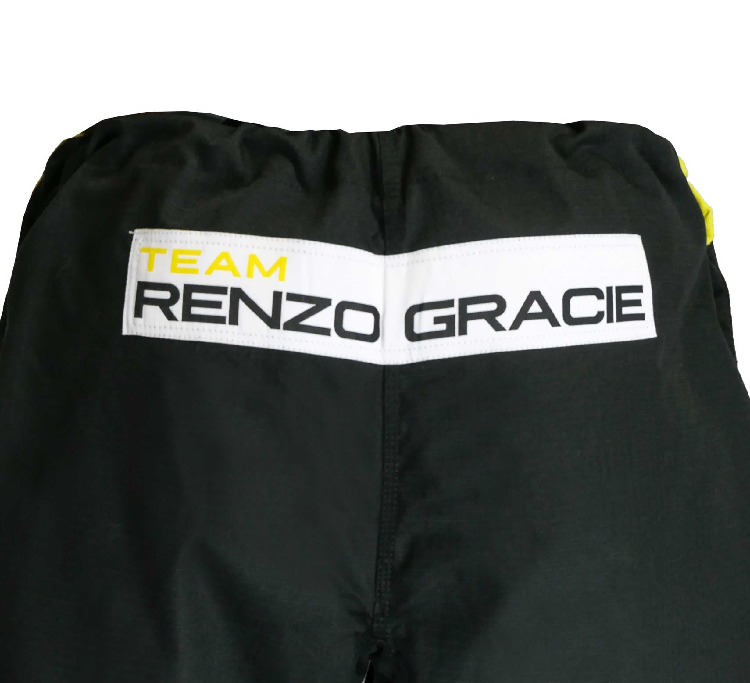 Close-up of the back waistband of black Renzo Gracie Superlite Gi pants featuring a white patch with "TEAM RENZO GRACIE" in black and yellow letters.