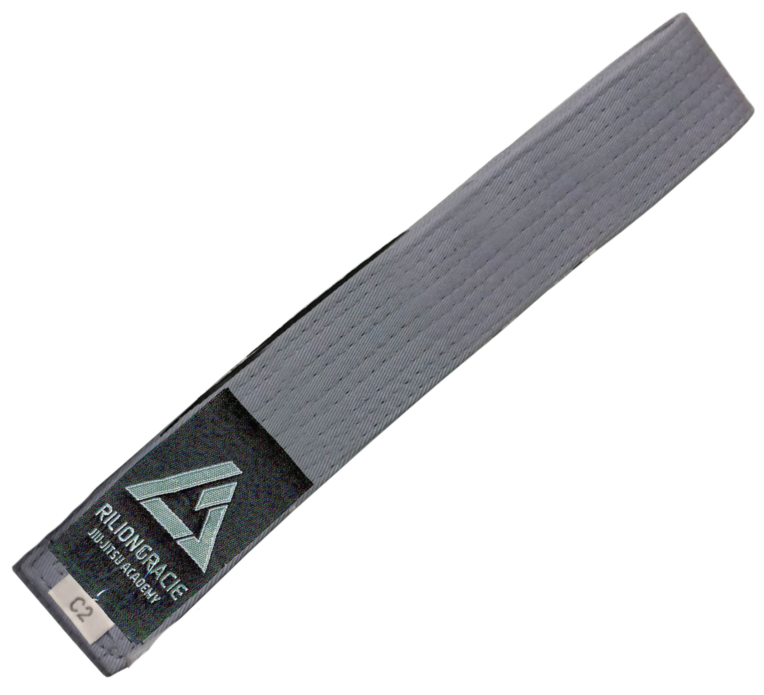 The Kids Rilion Gracie Belt Grey features a black patch with the Rilion Gracie logo and "JIU JITSU ACADEMY" text, plus a small white C2 label stitched on one end.