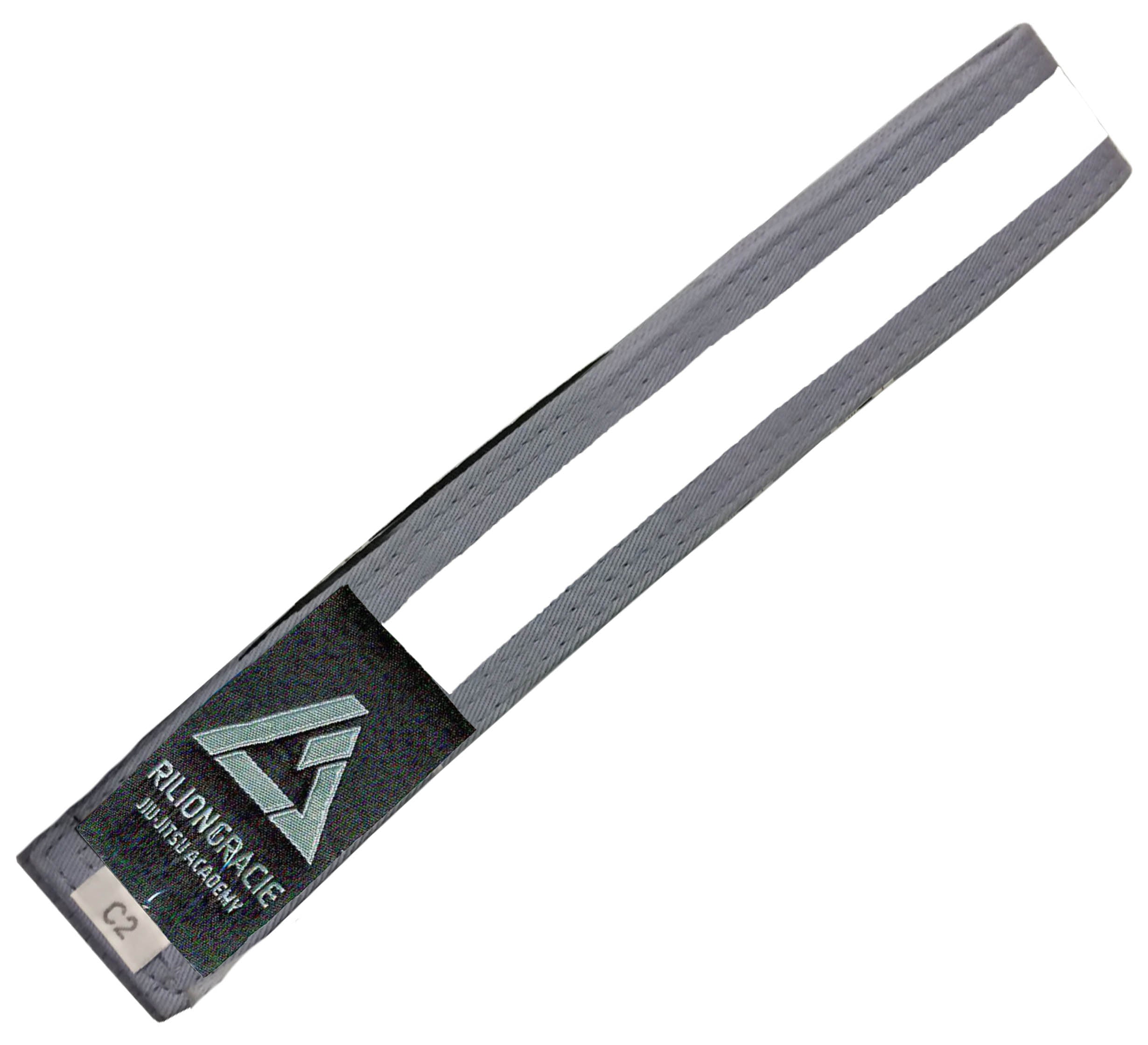 The Kids Rilion Gracie Belt Grey/White features a gray belt with a white stripe, a black patch displaying the Rilion Gracie Jiu-Jitsu Academy logo, and a small C2 label on one end.
