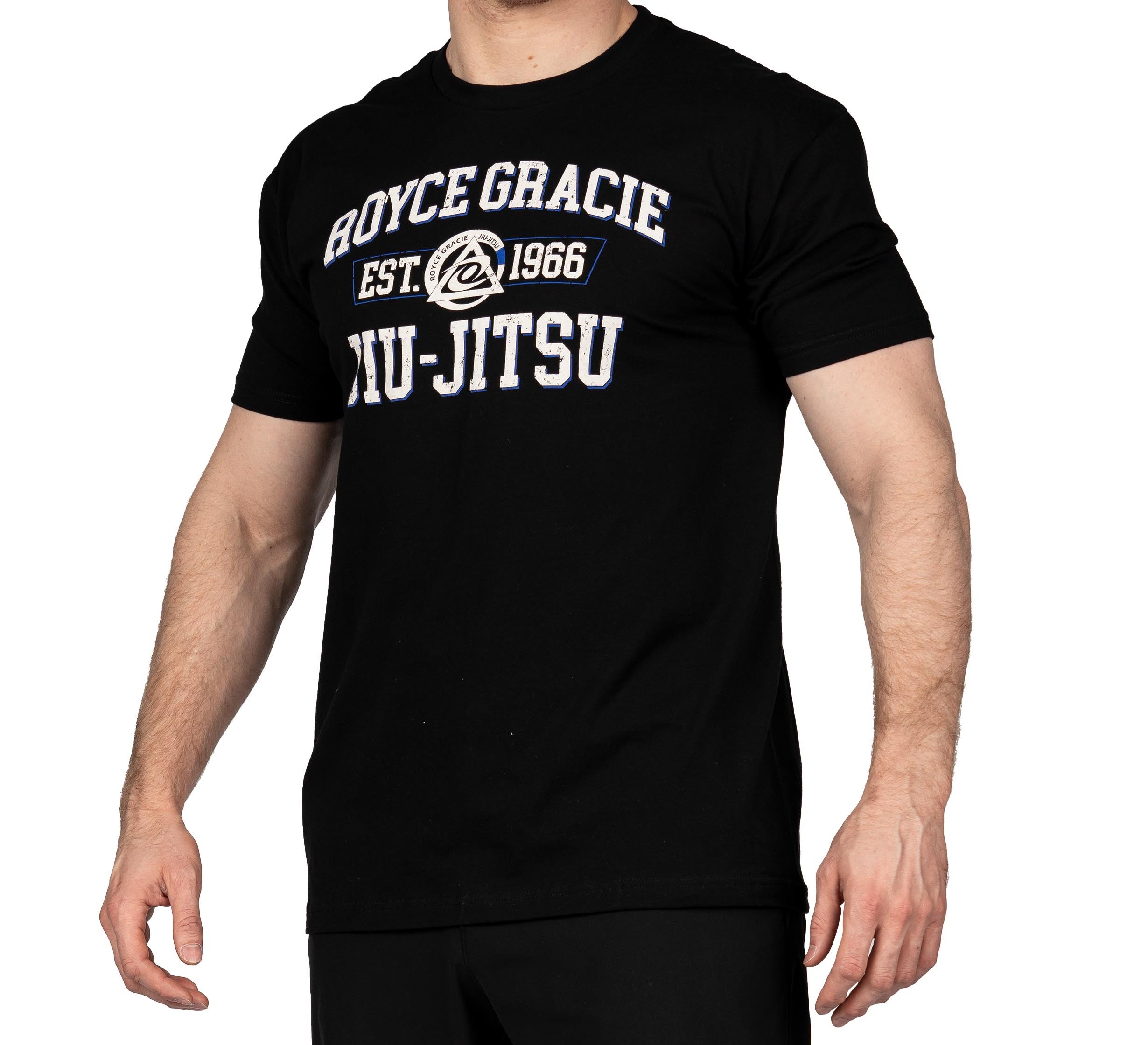 A person wearing the Royce Gracie Collegiate T-Shirt, featuring a black color with white and blue "ROYCE GRACIE EST. 1966 JIU-JITSU" text and a circular logo in the center. The person's head is not visible in the image.