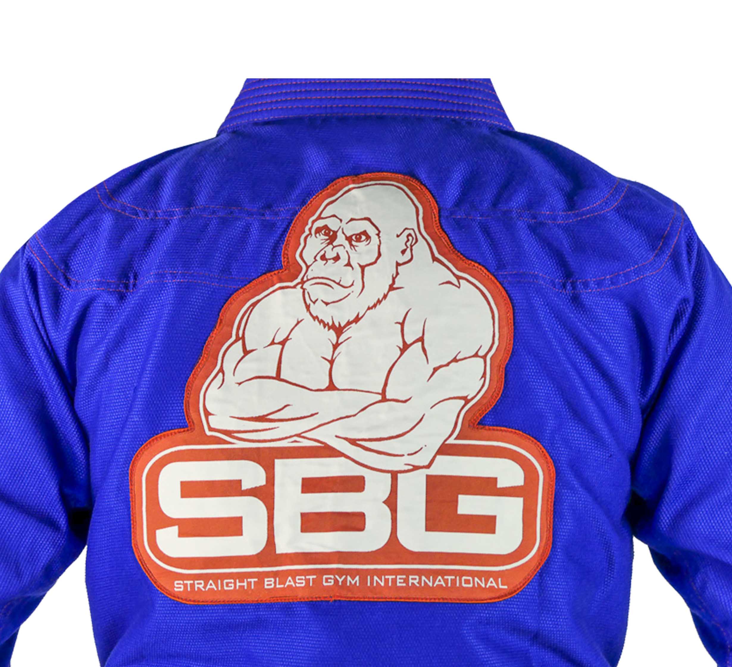 The SBG One Tribe Blue Super Lite Womens Gi jacket features a large back patch of a muscular cartoon gorilla with folded arms above bold "SBG" letters and "Straight Blast Gym International.