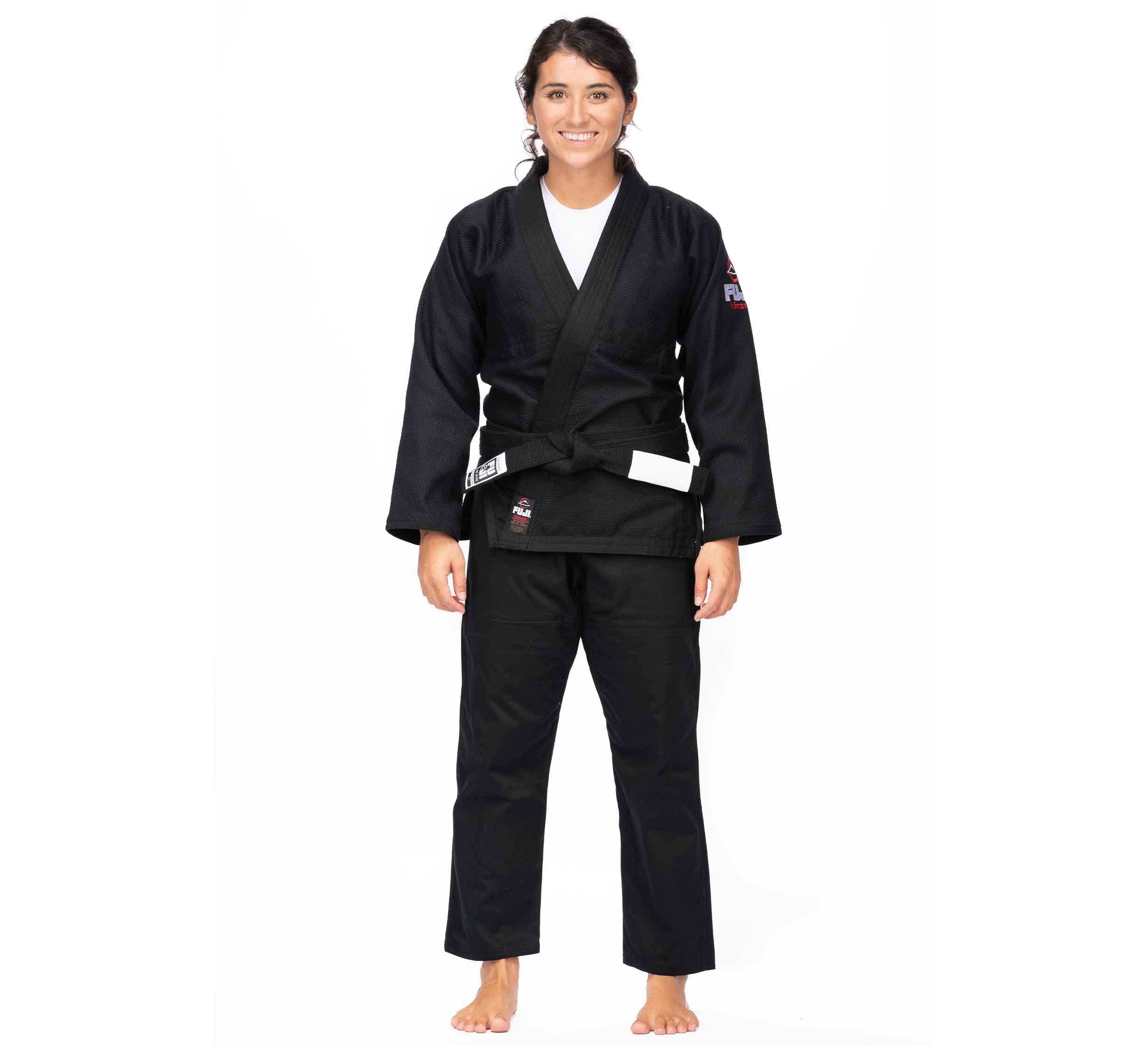 A woman smiles barefoot in the All Around BJJ Gi Black (Unisex Size) with a white belt, set against a plain white background.