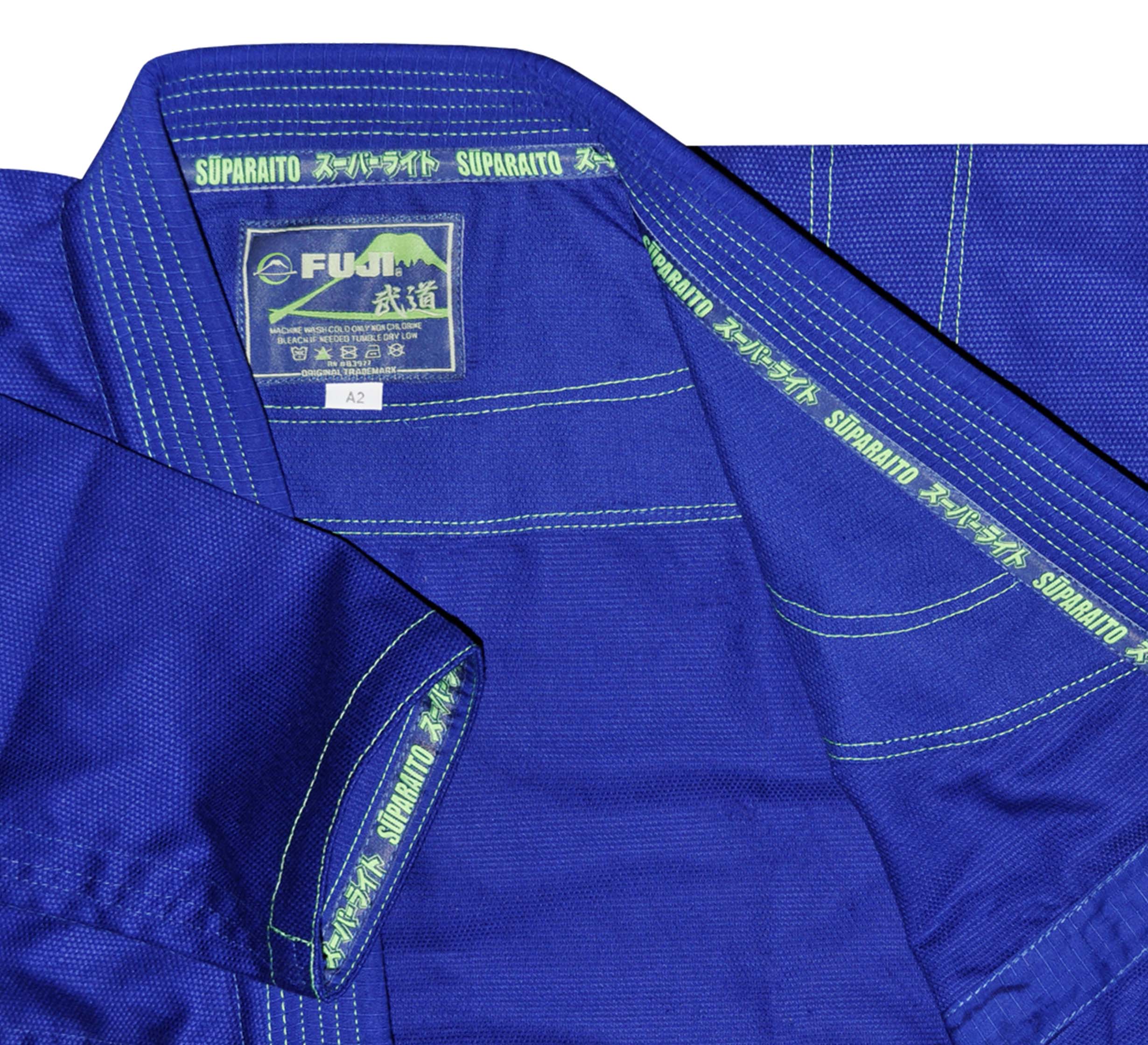 Close-up of the blue Suparaito BJJ Gi jacket featuring detailed stitching, green Suparaito trim, and a brand label with Japanese characters on the inside collar.