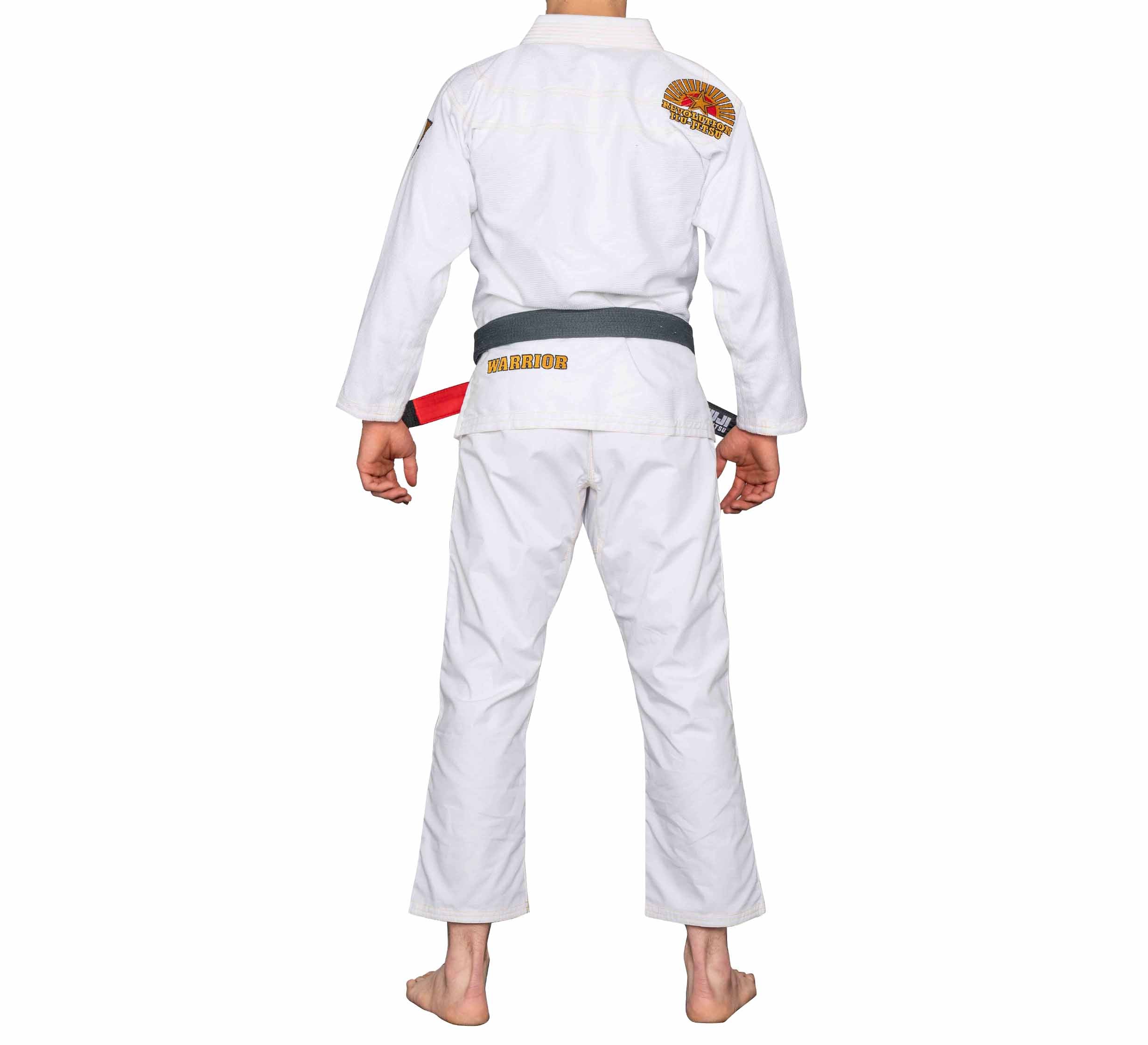 A person stands barefoot, facing away from the camera, wearing the BJJ Revolution Warrior Gi in white with a gray belt featuring a red stripe, set against a plain white background.