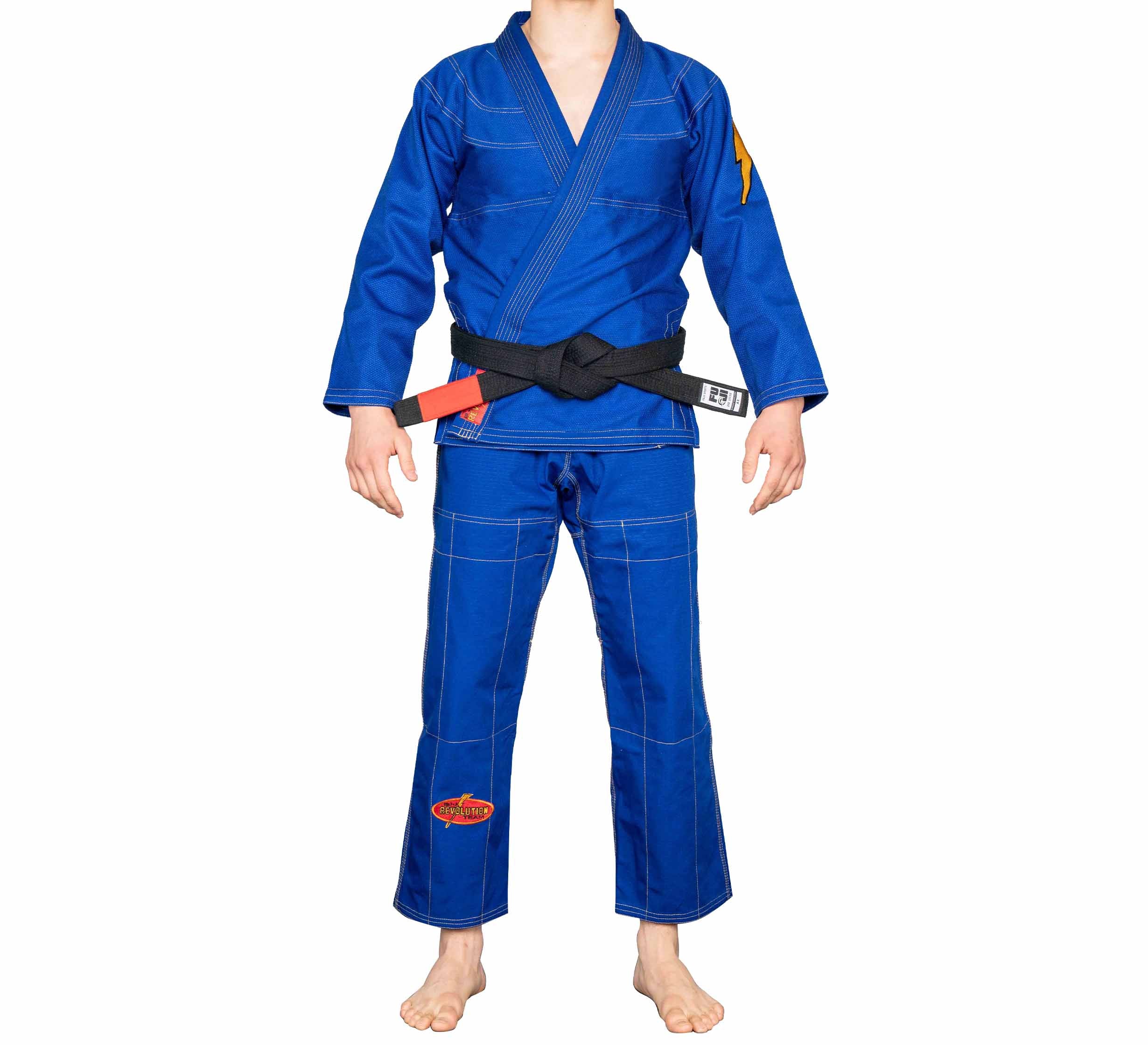 A person stands barefoot against a plain white background wearing the blue BJJ Revolution Warrior Gi with a black belt. Their head is not visible in the image.