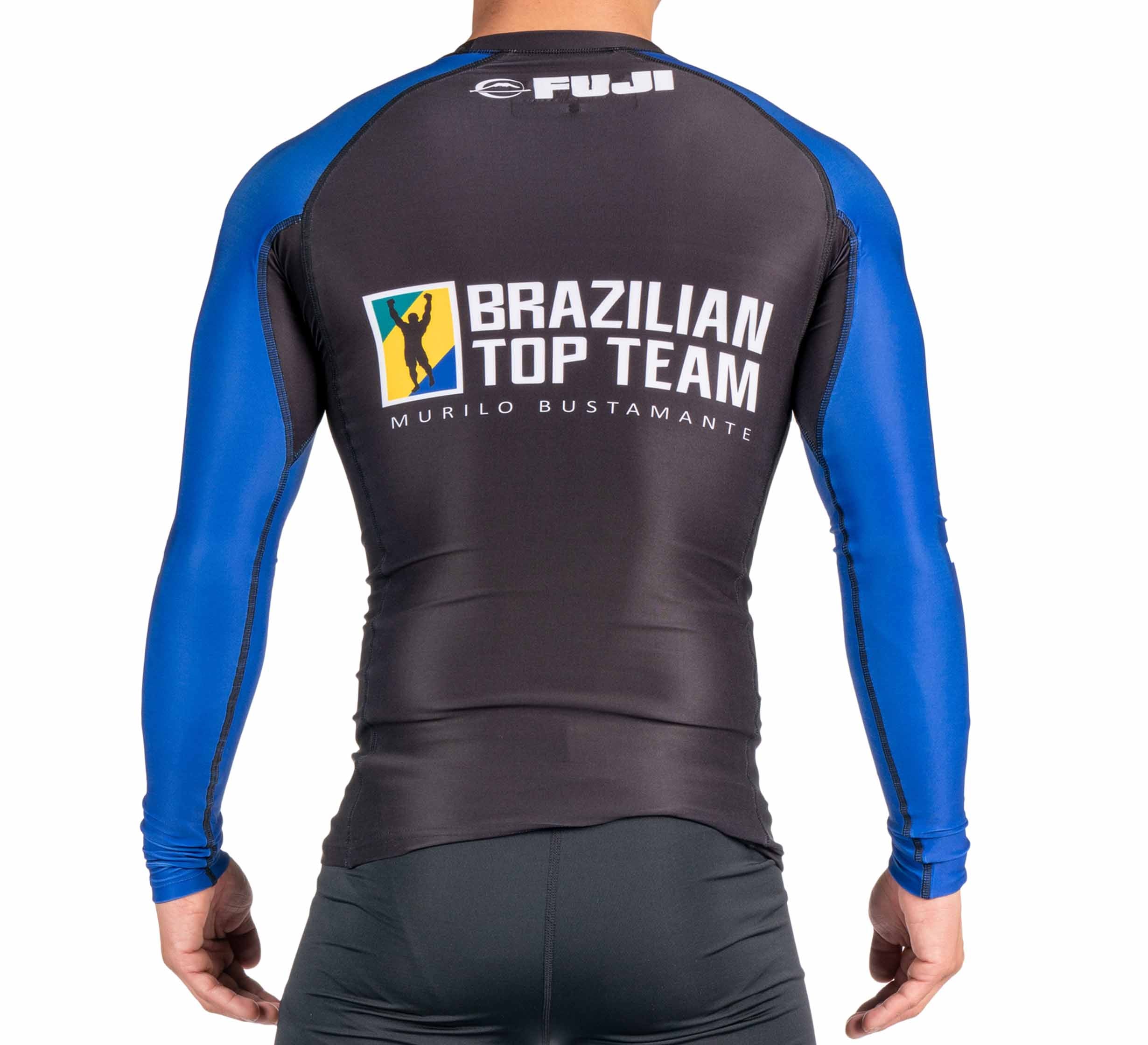 A person is shown from behind wearing the BTT Ranked Long Sleeve Rashguard (NEW) in black and blue, featuring "Brazilian Top Team Murilo Bustamante" and a logo printed on the back.