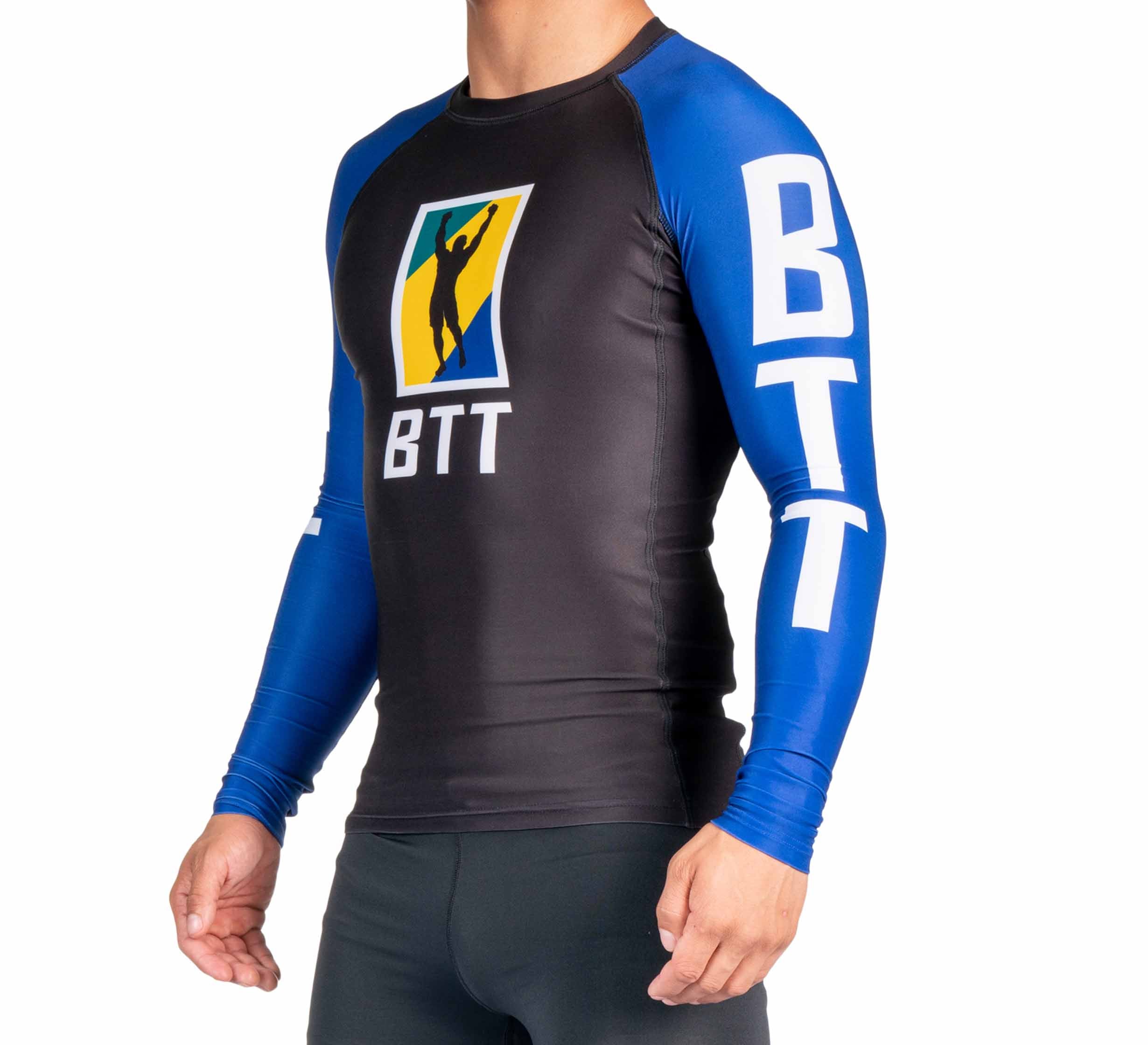 A person wears the BTT Ranked Long Sleeve Rashguard (NEW), a black and blue shirt featuring "BTT" in white on the sleeves and chest, plus a colorful graphic logo. Their face isn’t visible.