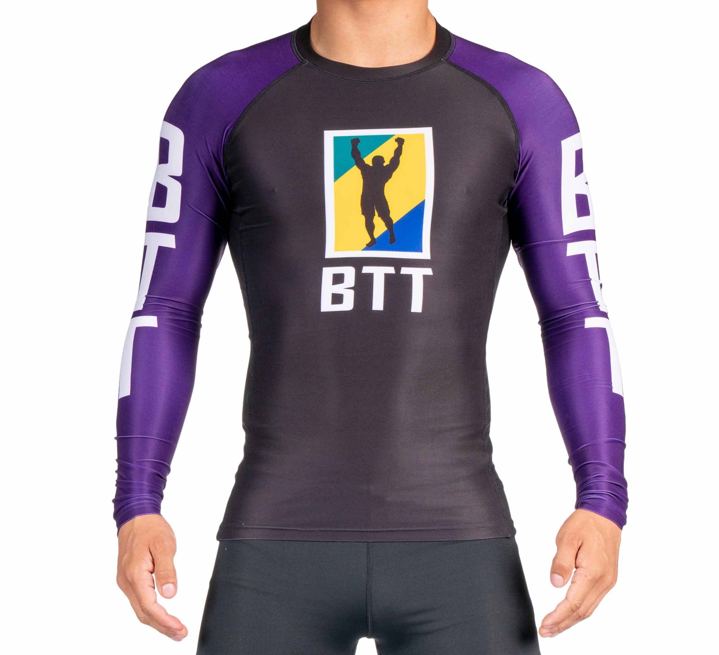 A person is wearing the BTT Ranked Long Sleeve Rashguard (NEW), featuring black and purple colors, BTT lettering, and a logo with a raised-arm silhouette on a yellow and blue background. The person's head is not visible.