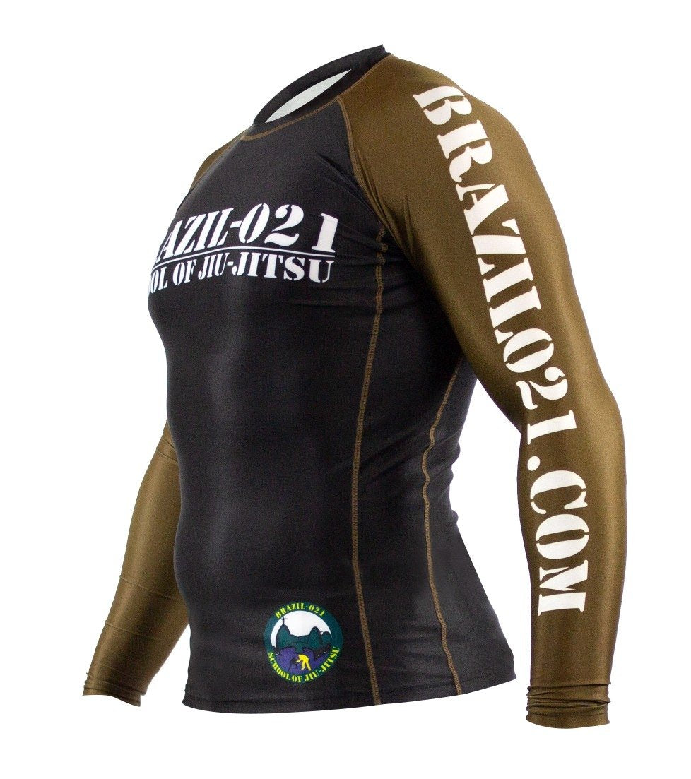 The BRAZIL 021 Ranked Rashguard features black and olive green long sleeves, "BRAZIL-021 SCHOOL OF JIU-JITSU" on the chest, "BRAZIL021.COM" on the sleeve, and a circular Brazil 021 logo near the waist.