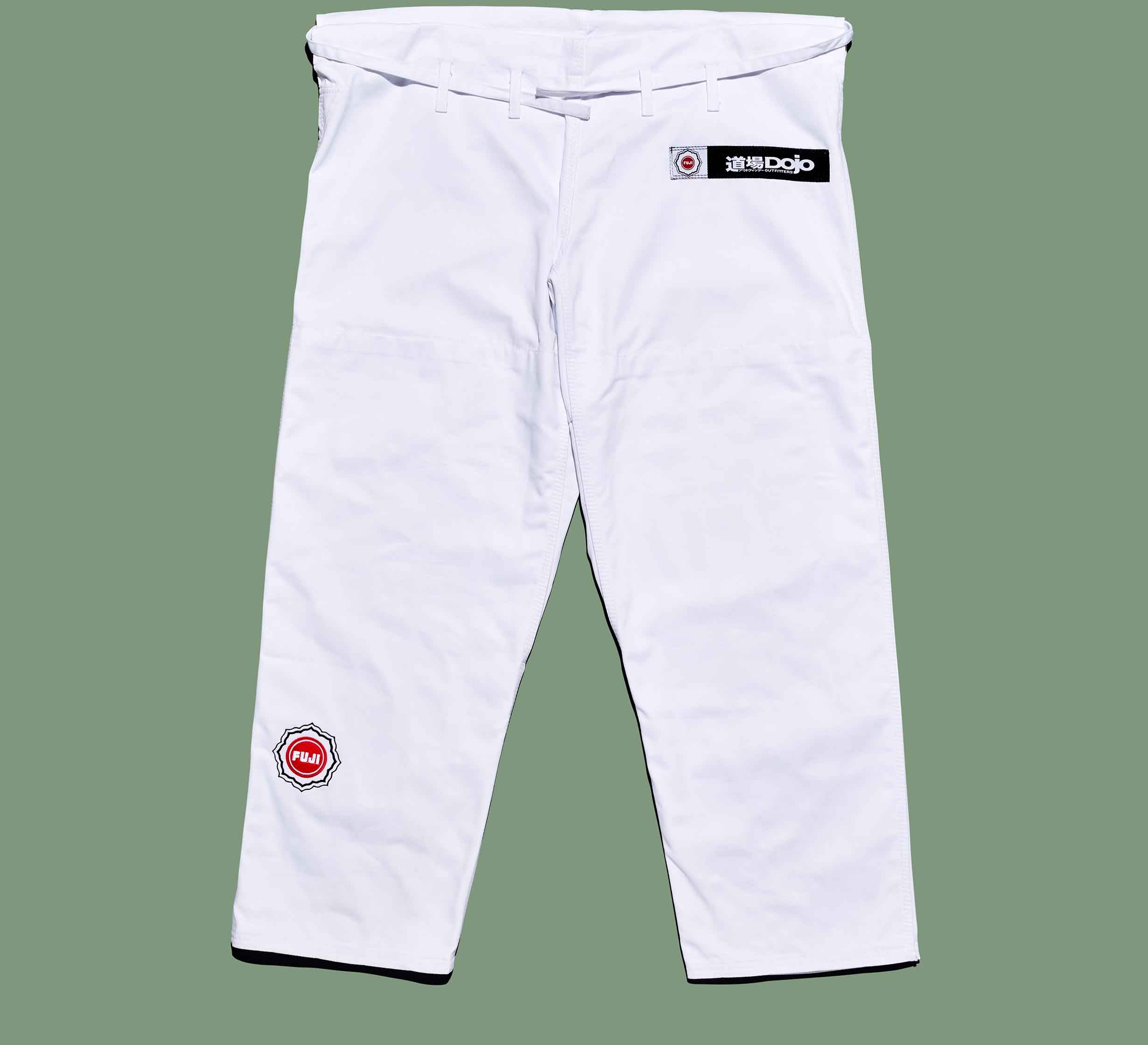 The Dojo Outfitters x FUJI Judo Gi pants feature patches on the left thigh and right hip, reinforced stitching, and belt loops at the waist, shown against a green background.