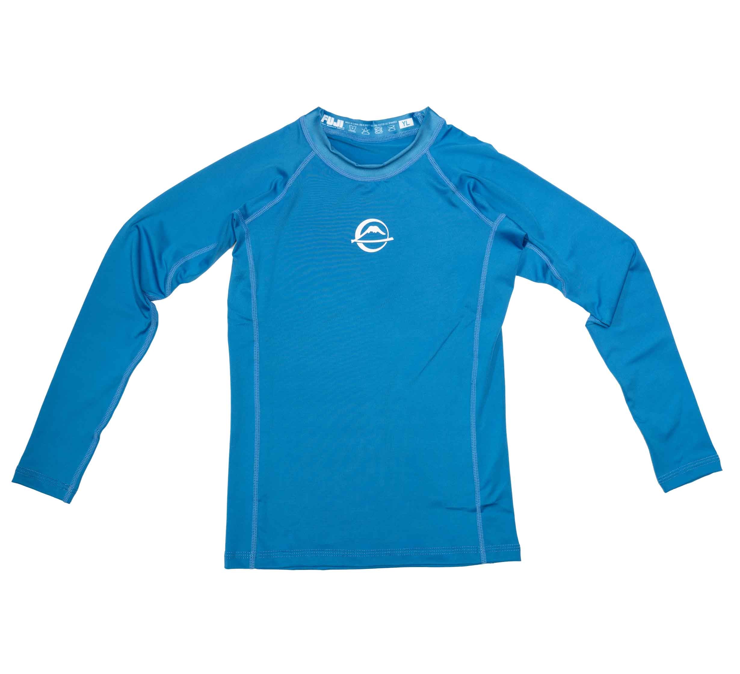 The Baseline Kids Rashguard Blue features long sleeves, white stitching, and a small white chest logo, displayed flat on a white background.