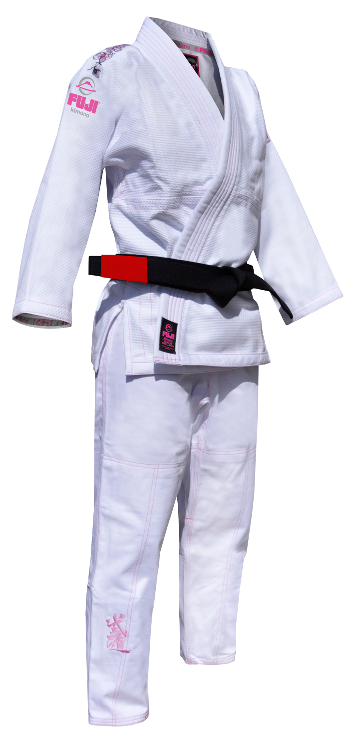 The Blossom Kids Jiu Jitsu Gi White features pink stitching and logos, displayed on a plain background, and is shown with a black belt with a red bar tied around the waist.