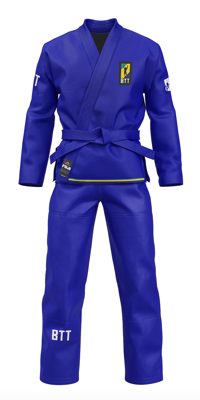 The BTT Standard Women's Gi in blue comes with a blue belt, displays "BTT" on the left sleeve and leg, and features a yellow, green, and black BTT logo patch on the left chest. The gi is shown on a white background.