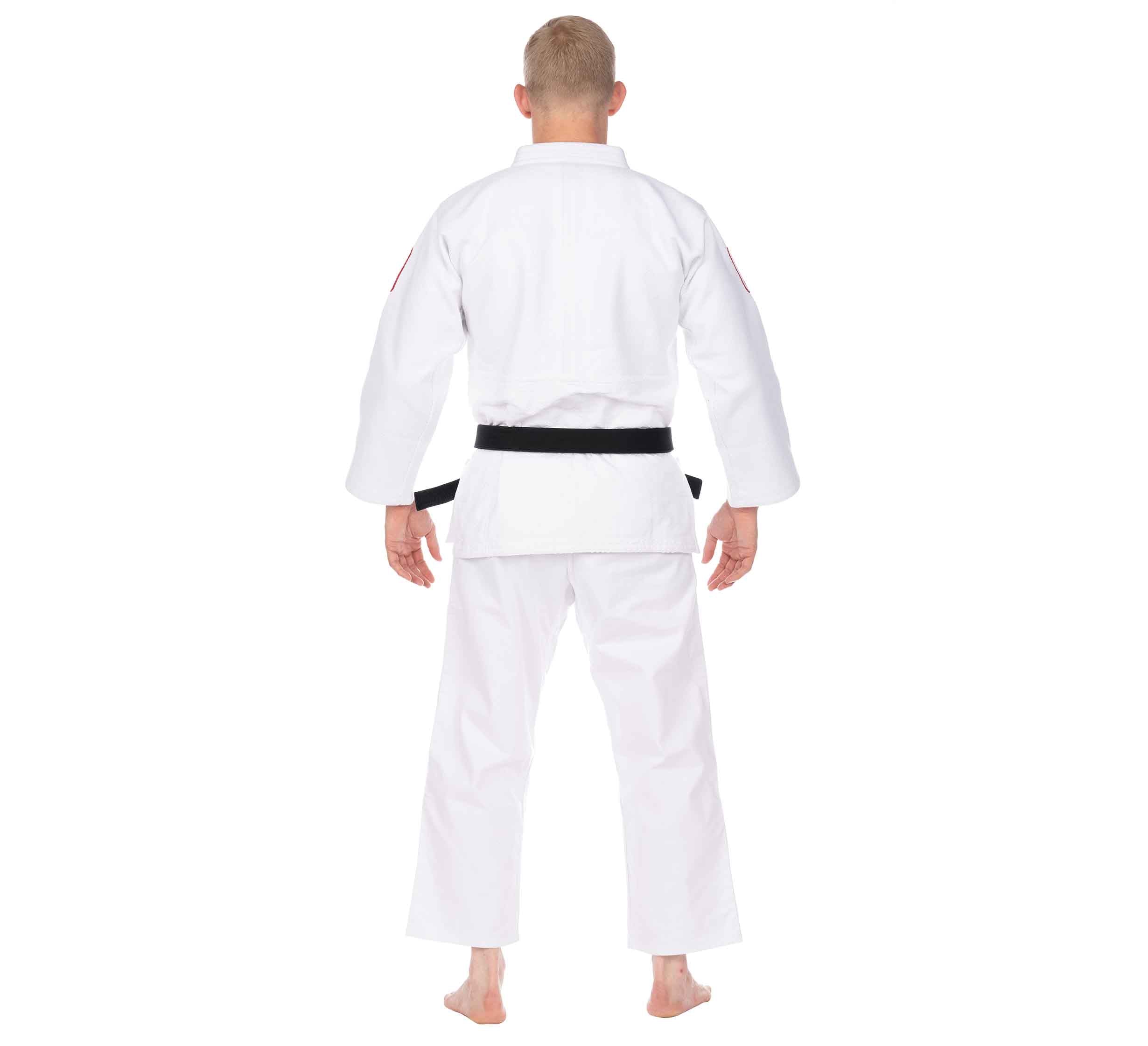 A person with short blond hair stands barefoot, facing away from the camera, wearing the USA Judo Double Weave Gi 2.0 White with a black belt on a plain white background.