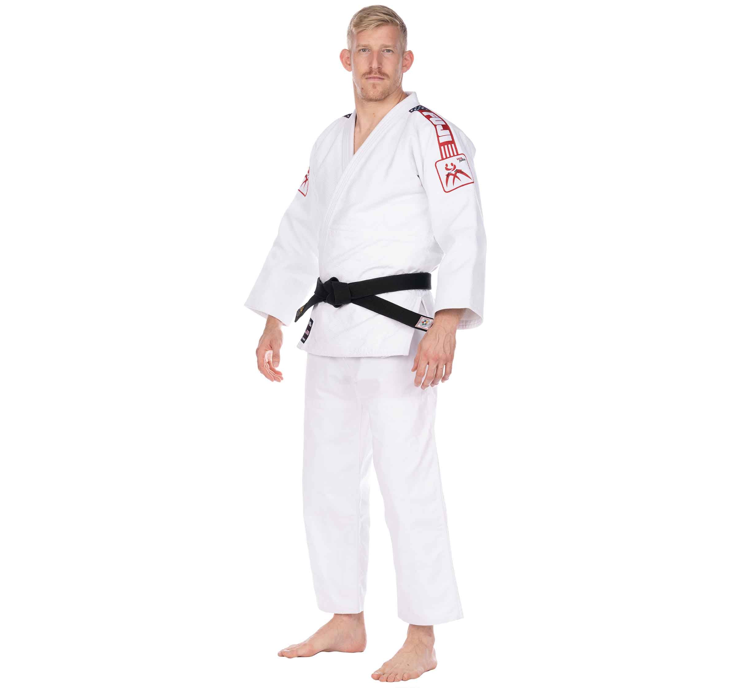 A person wearing the USA Judo Double Weave Gi 2.0 White with a black belt stands barefoot on a white background, looking at the camera with a neutral expression.