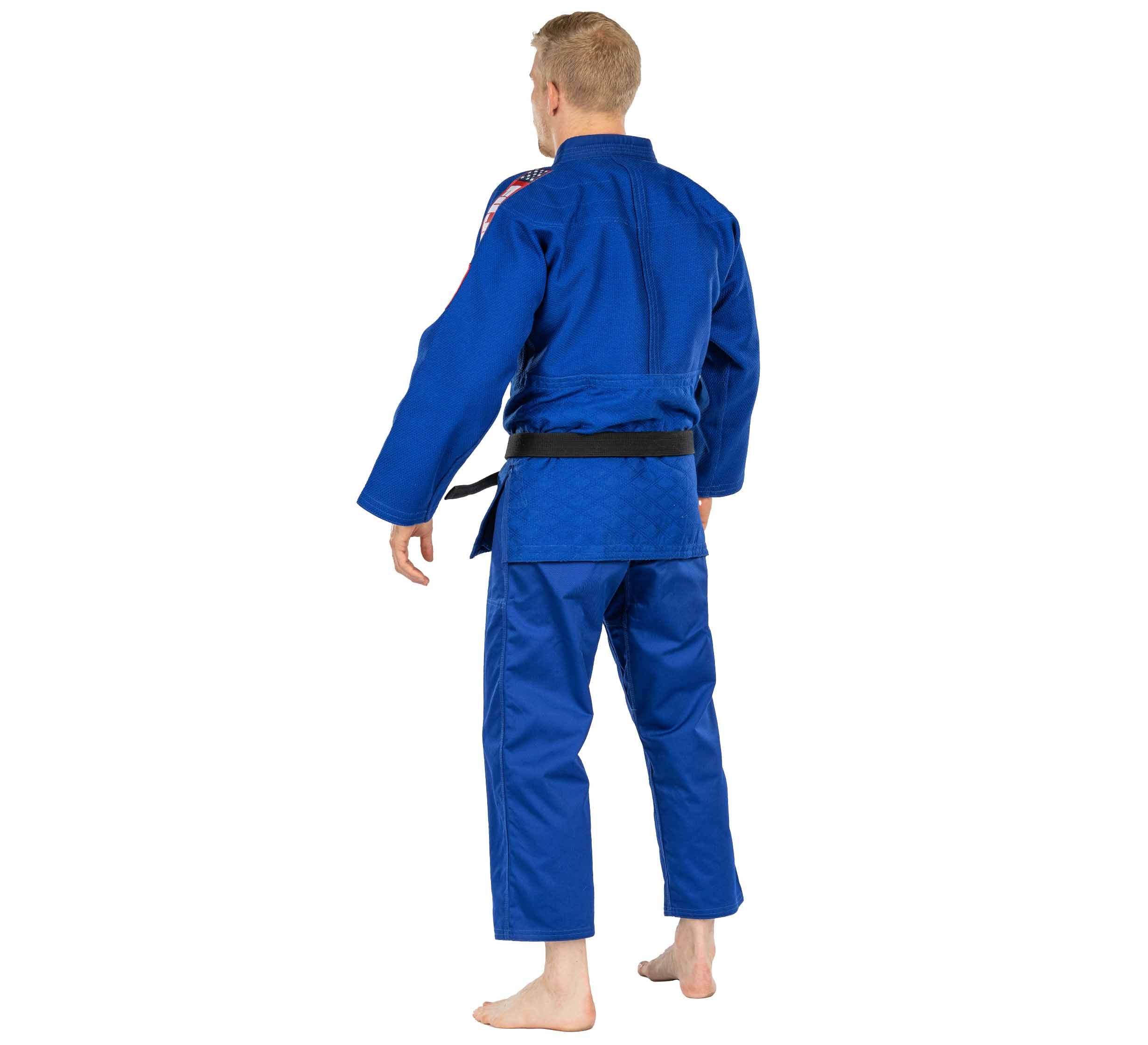 A person stands barefoot on a white background, facing away from the camera, wearing the USA Judo Single Weave Gi 2.0 Blue with a black belt.