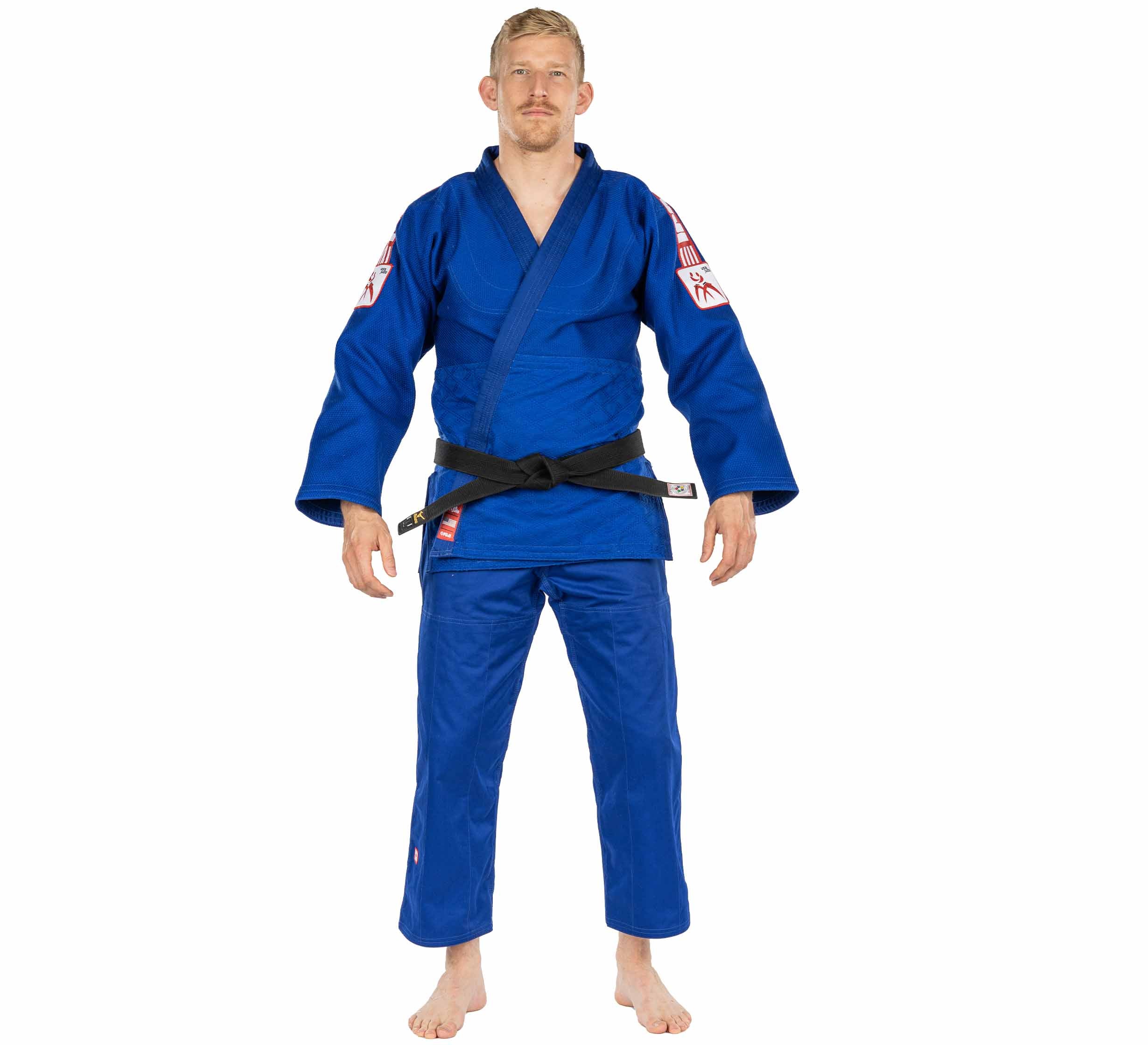 A man stands barefoot, facing forward with arms relaxed, wearing the USA Judo Double Weave Gi 2.0 Blue and a black belt, against a plain white background.