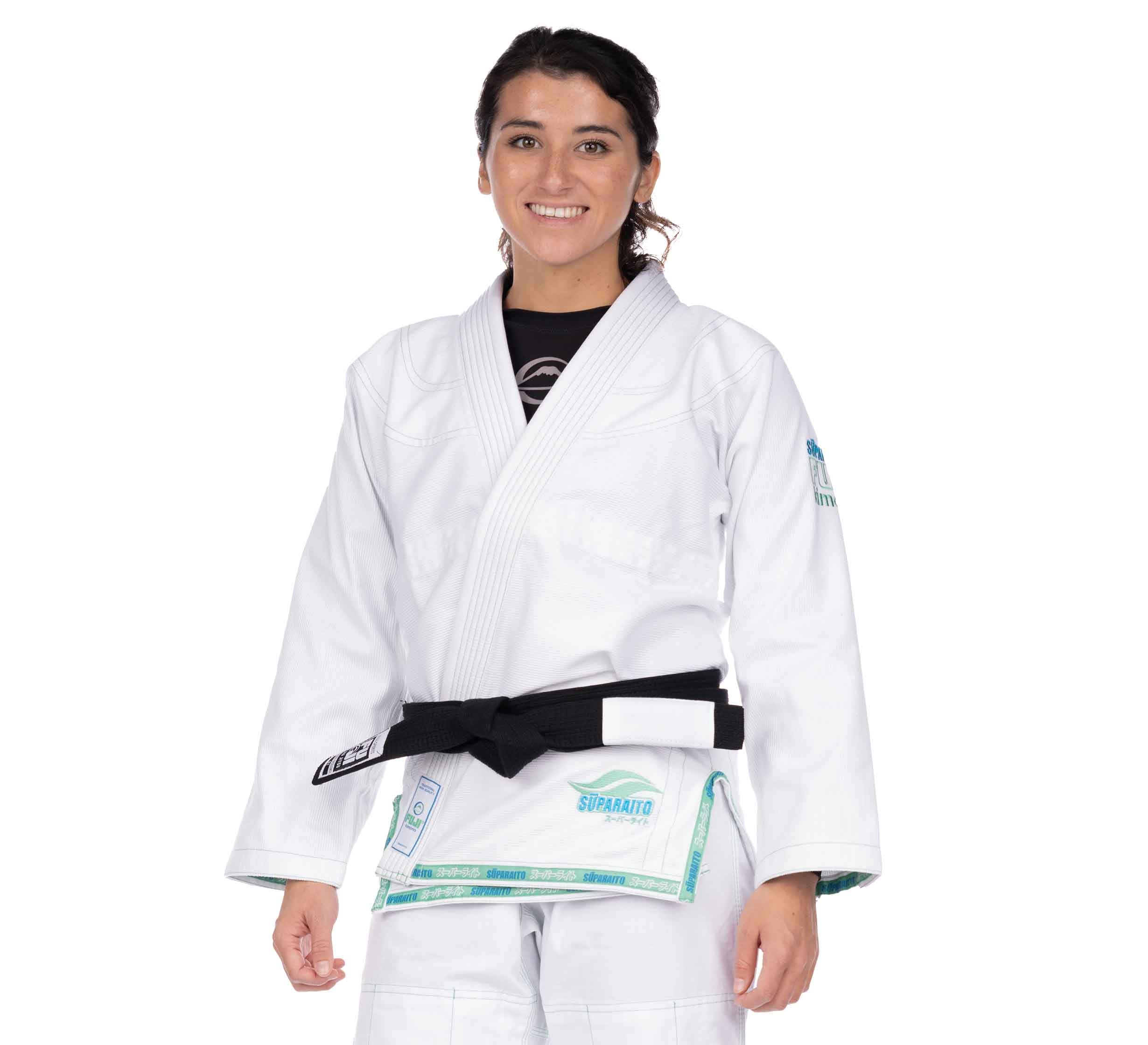 A woman smiles while standing in the Suparaito Girl's BJJ Gi Teal with a black belt, set against a plain white background.