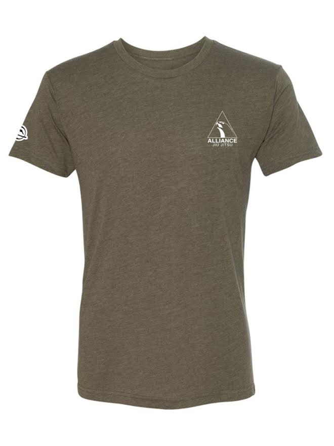 The Alliance Essential T-Shirt Green features an olive green color, short sleeves, a small white Alliance logo with a triangle design on the left chest, and a white emblem on the left sleeve. The shirt is shown against a plain background.