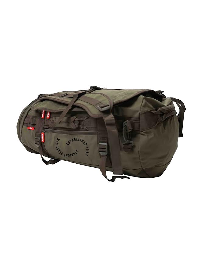 The SBG Comp Duffle Military Green Bag features black straps and buckles, external zippered pockets, and “ESTABLISHED 1987” printed in a circular pattern on the side.