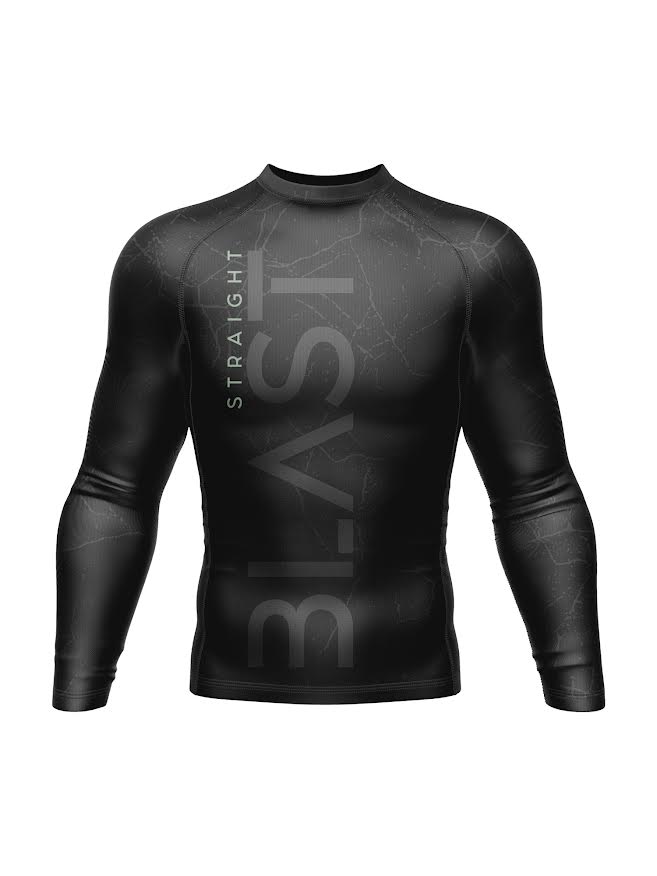 The SBG Concrete Long Sleeve Rashguard Black is a black compression shirt featuring a subtle marble pattern and bold STRAIGHT BLAST lettering running vertically and horizontally across the front.